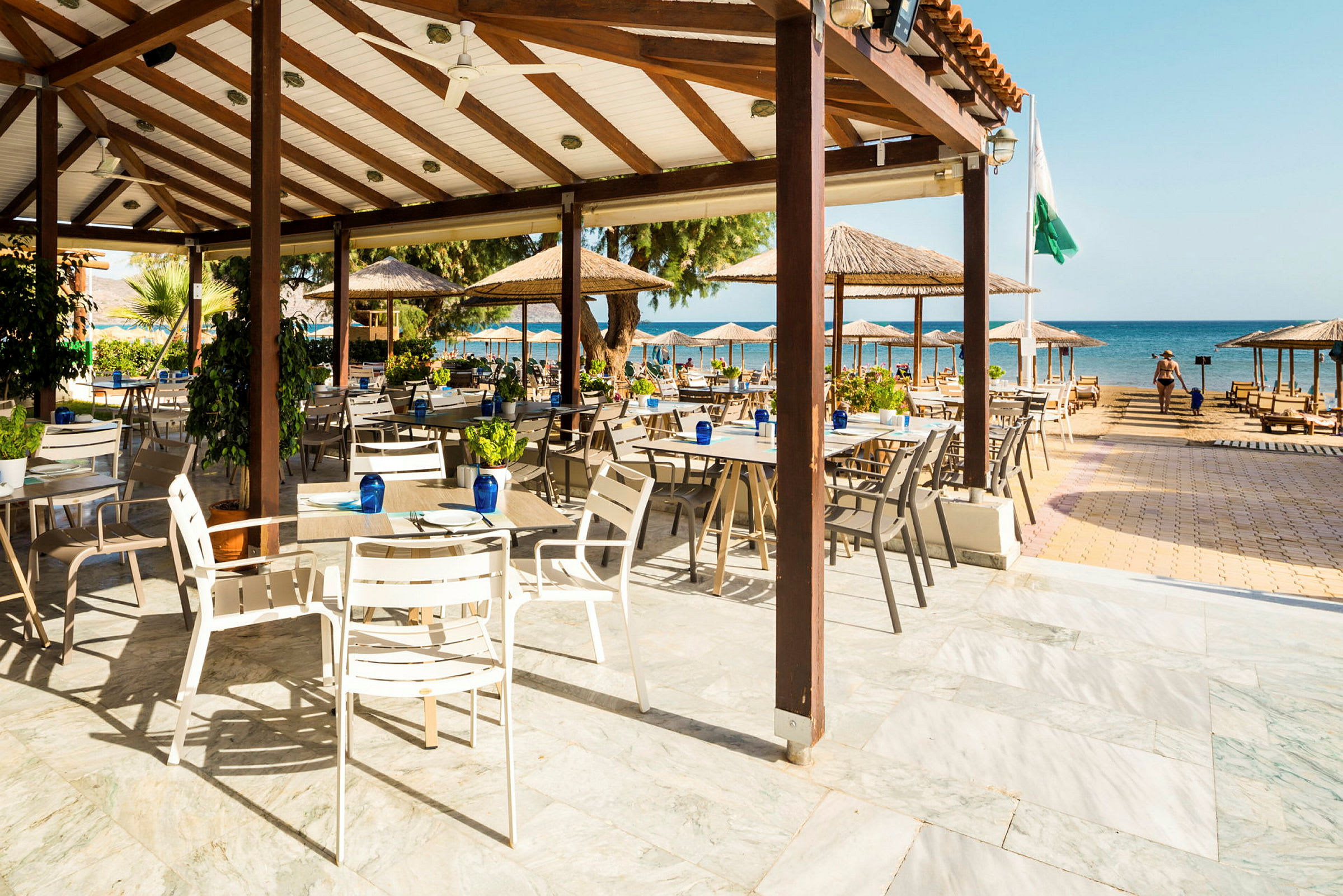 Åpen restaurant med utsikt over stranden og havet. (AI-generert tekst)