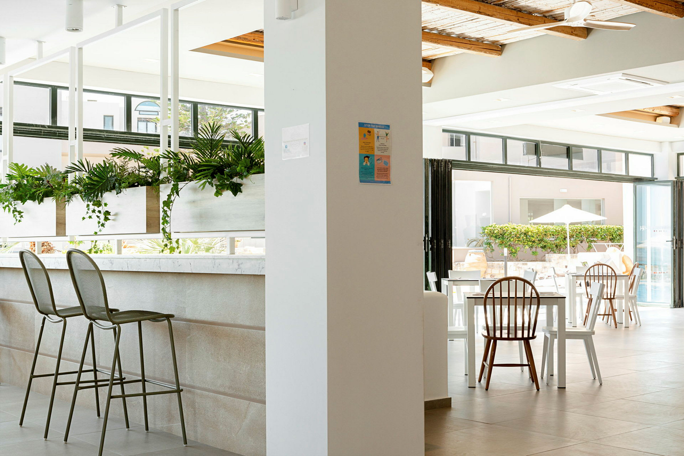 Interiør av en moderne og lys restaurant med sitteplasser og grønne planter. (AI-generert tekst)