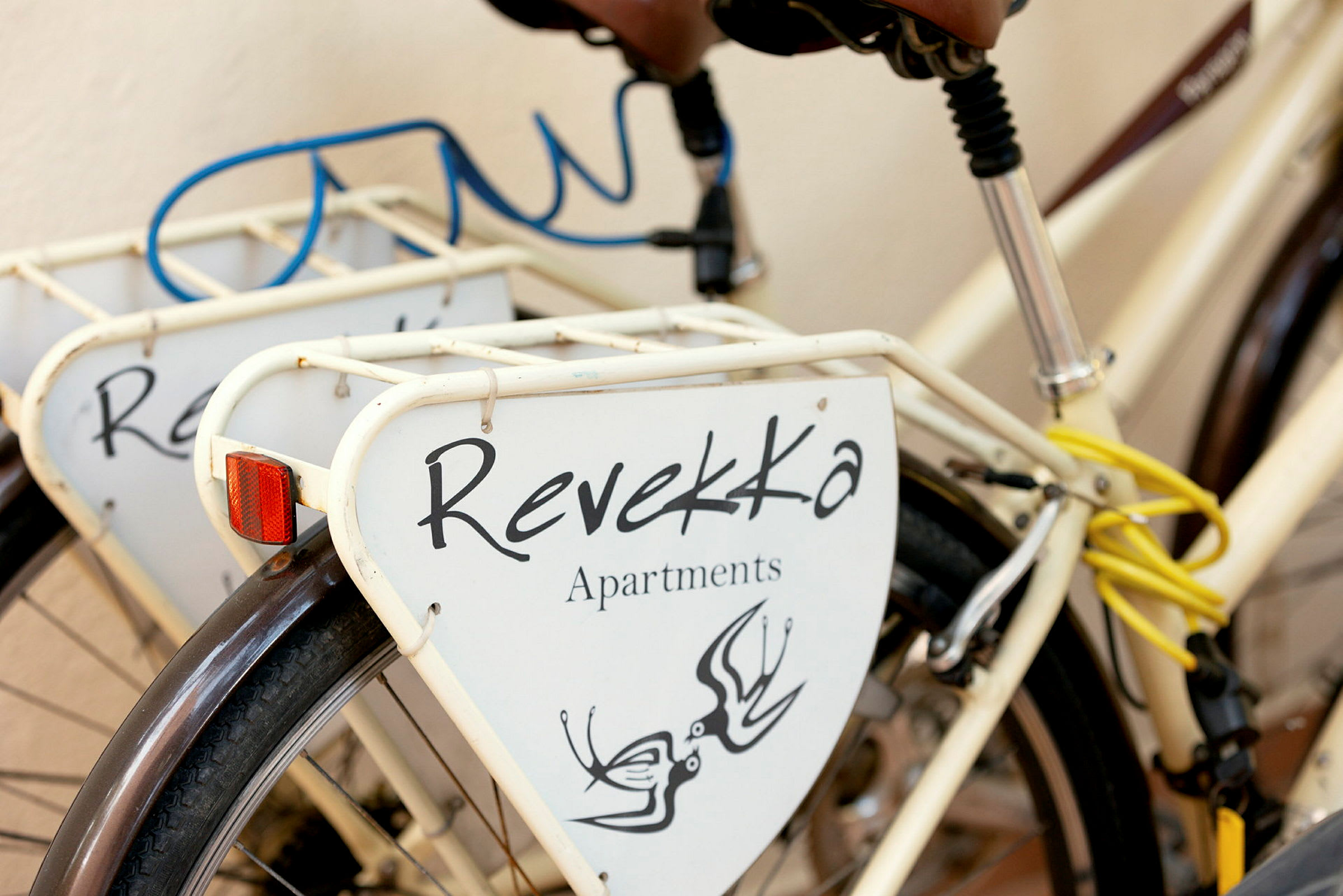 En sykkel med skilt som viser teksten 'Revekka Apartments'. (AI-generert tekst)