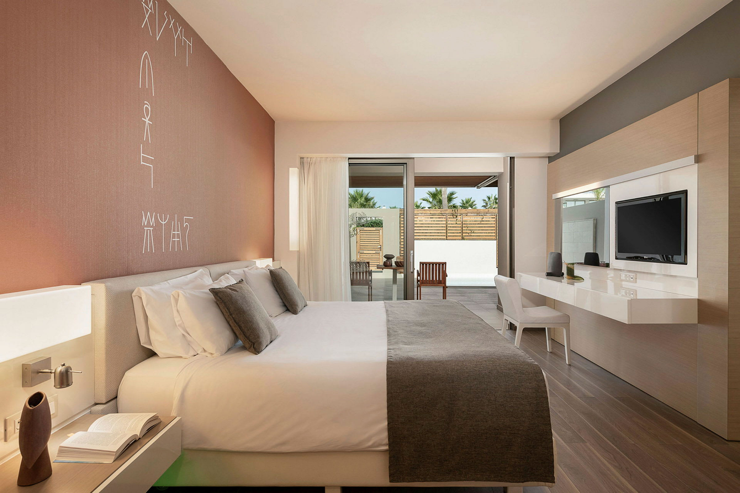 Moderne hotellrom med stor seng og skrivebord, åpent vindu mot en terrasse. (AI-generert tekst)
