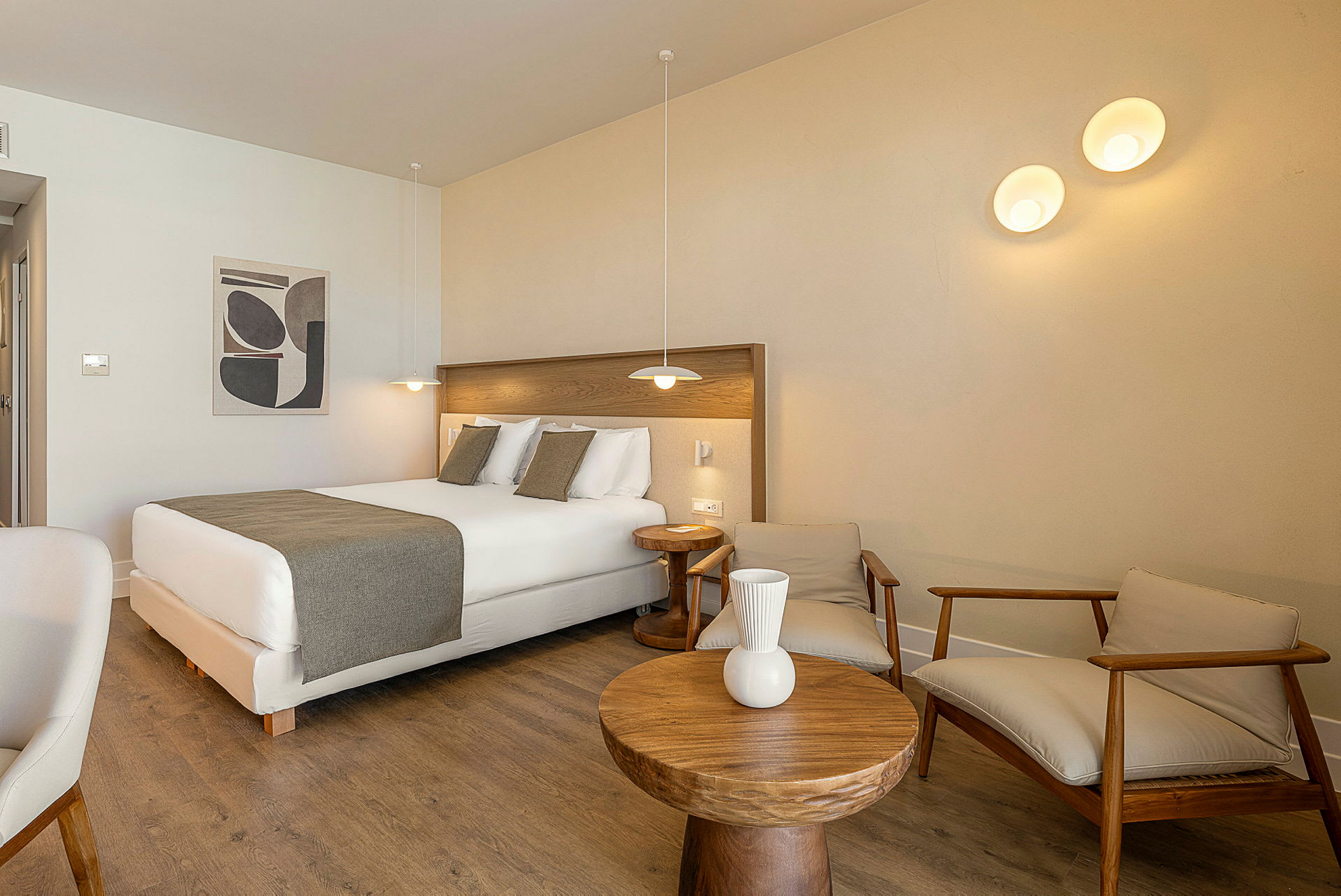 Et hotellrom med en dobbeltseng, tremøbler og moderne belysning. (AI-generert tekst)