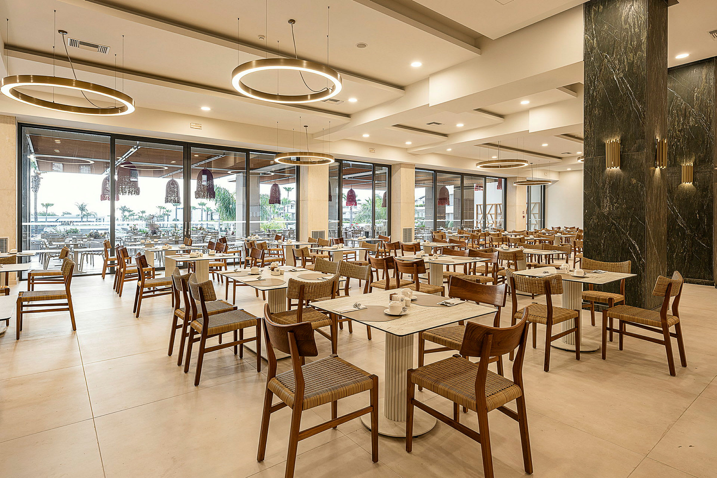 En restaurant med moderne møbler og glassvegger som vender ut. (AI-generert tekst)