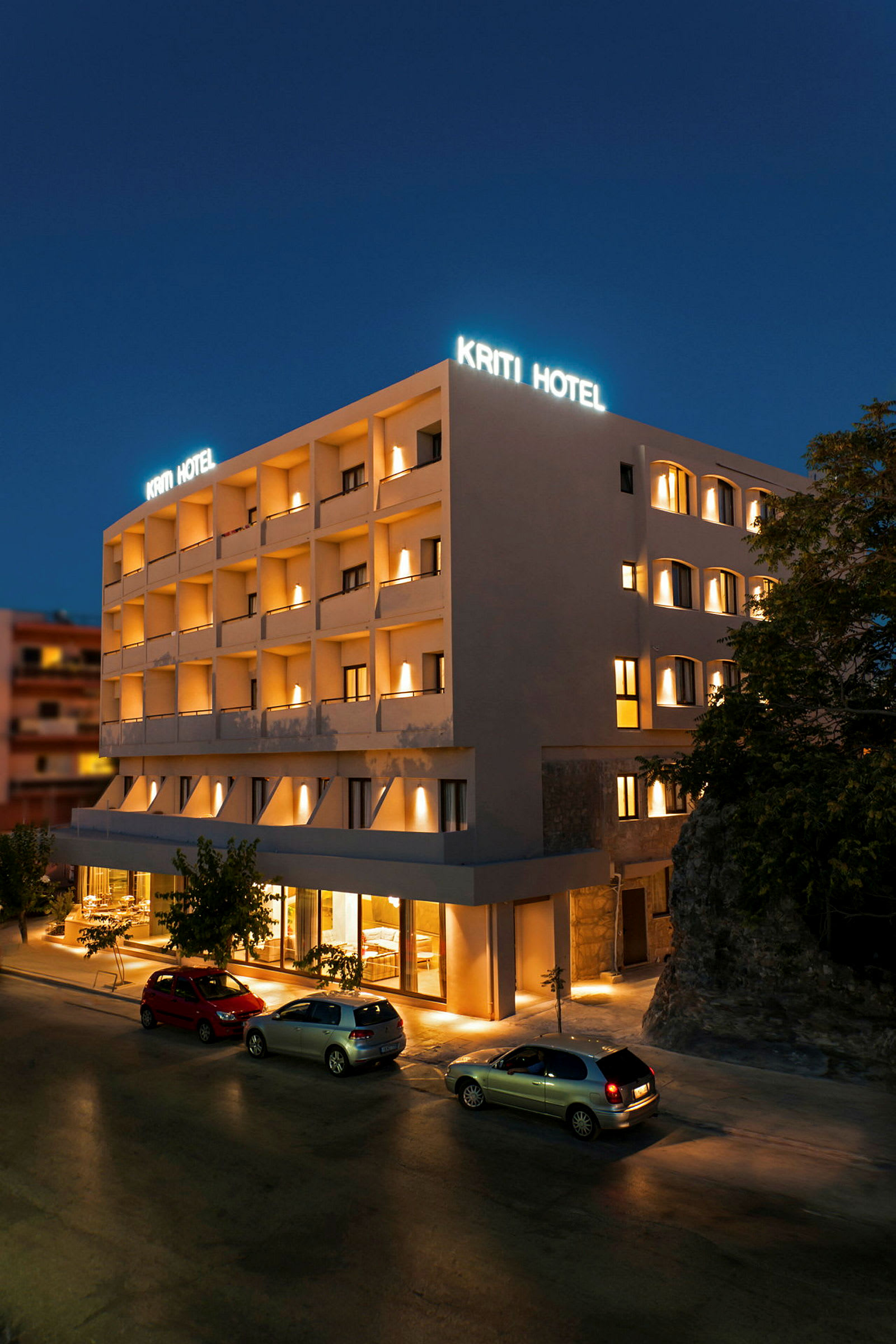 Hotellbygning om natten med opplyst skilt og fasade. (AI-generert tekst)