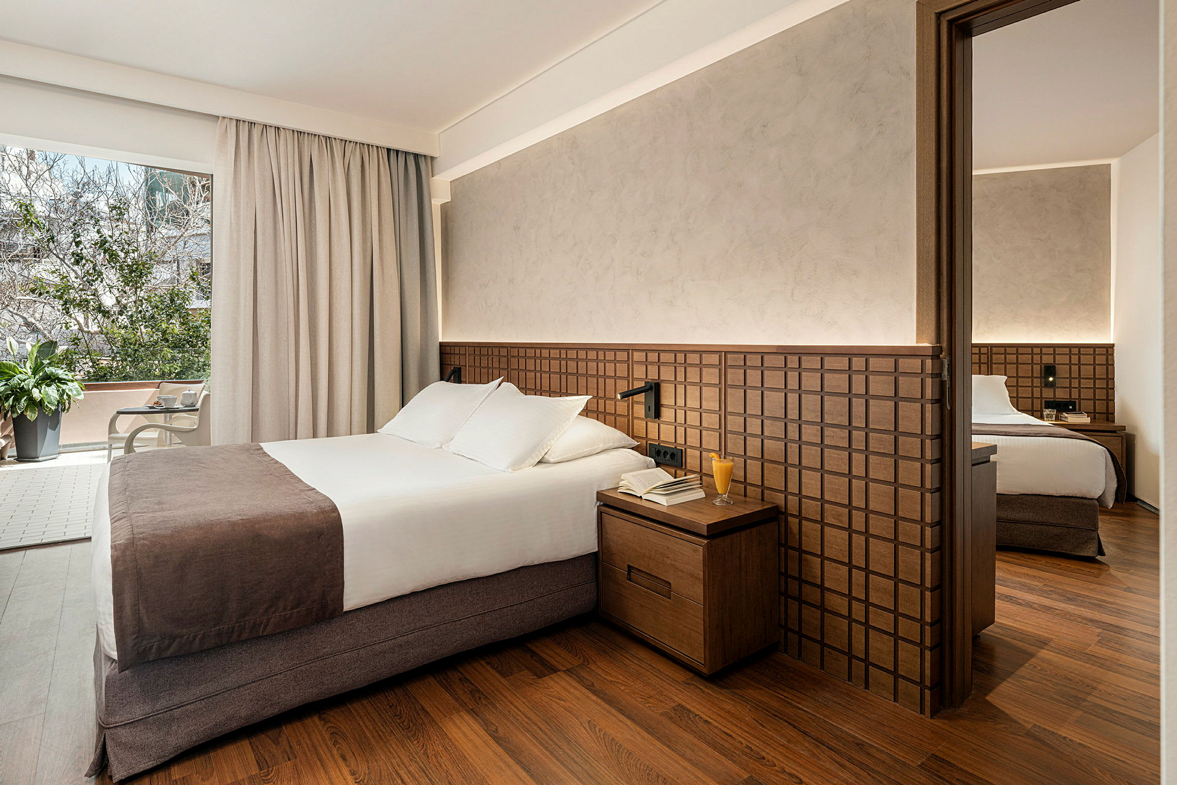 Hotellrom med dobbeltseng, nattbord og garderobe. (AI-generert tekst)