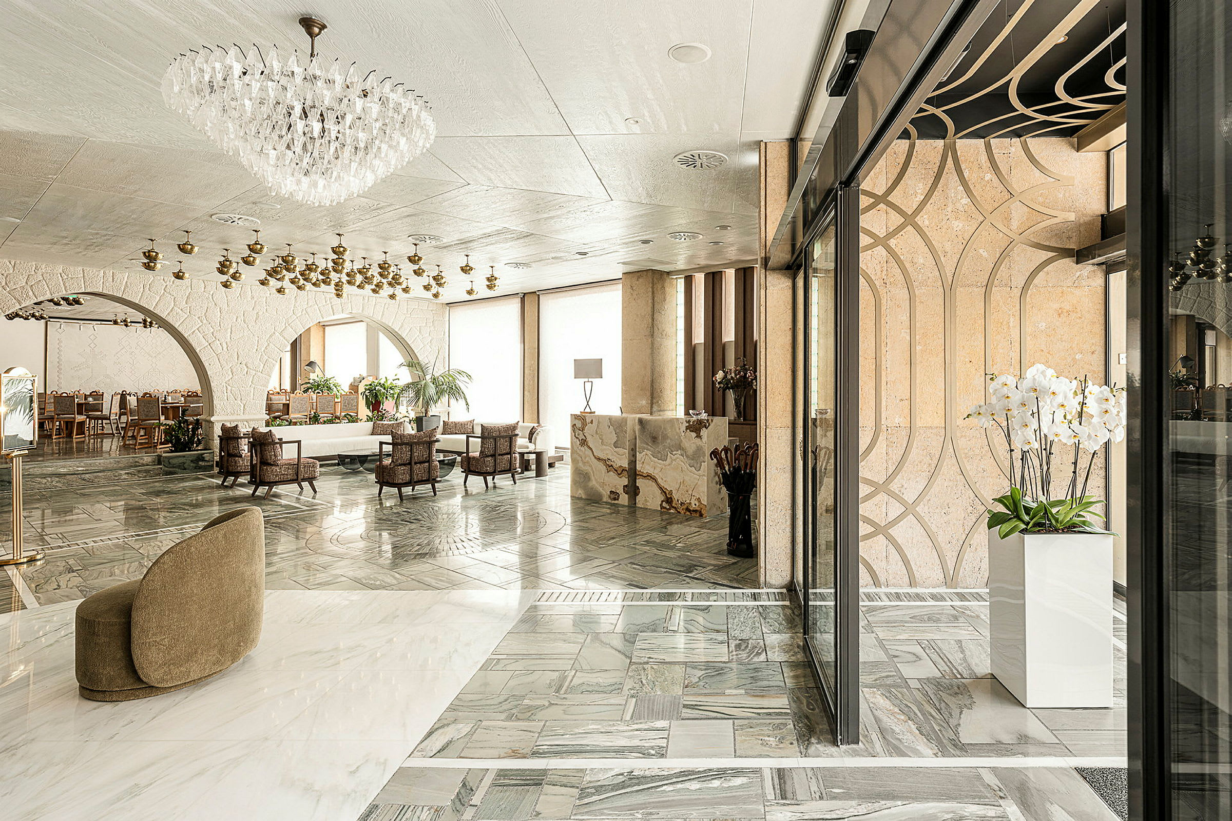 Elegant hotellobby med marmorgulv, lysekrone og moderne møbler. (AI-generert tekst)