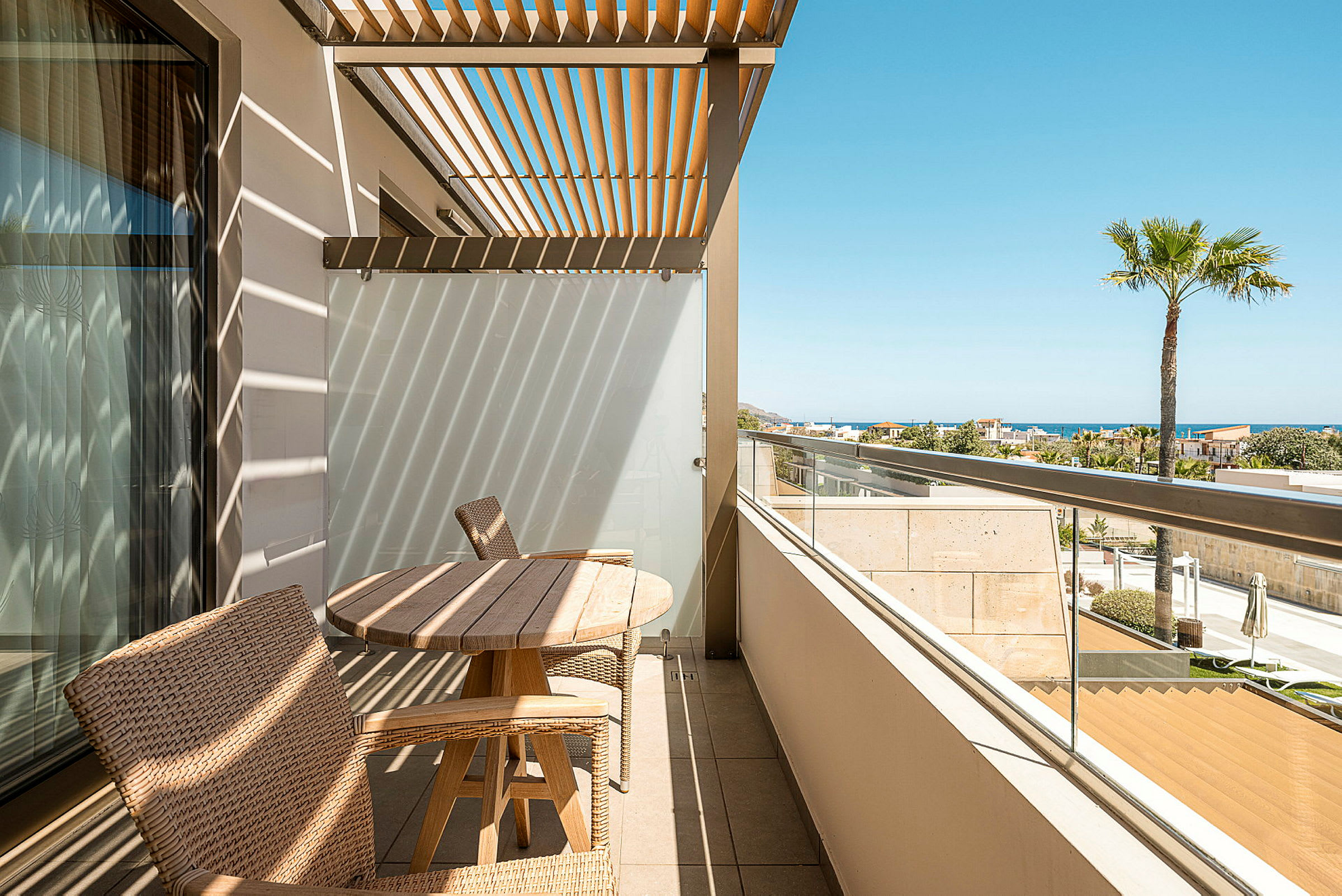 En terrasse med tremøbler og pergola, med havutsikt i bakgrunnen. (AI-generert tekst)