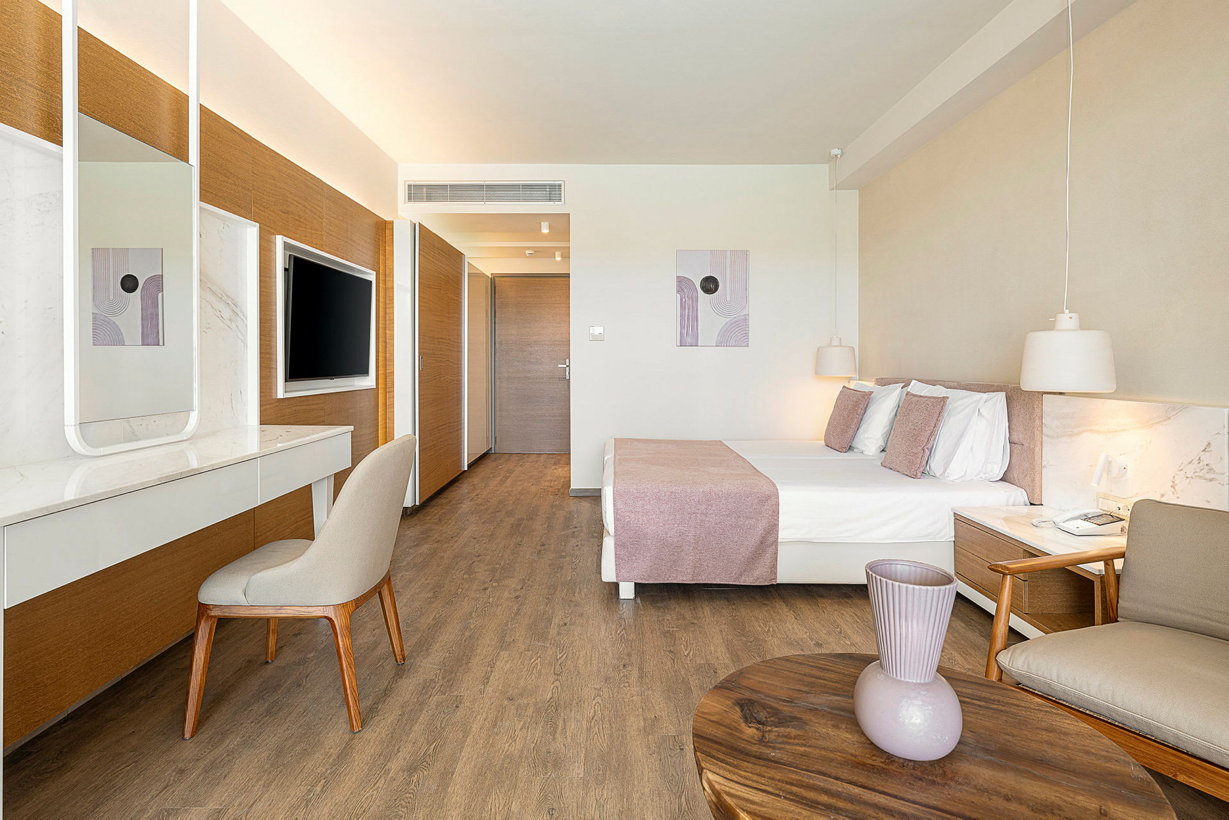 Bilde av et moderne hotellrom med en dobbeltseng, et skrivebord og en veggmontert TV. (AI-generert tekst)