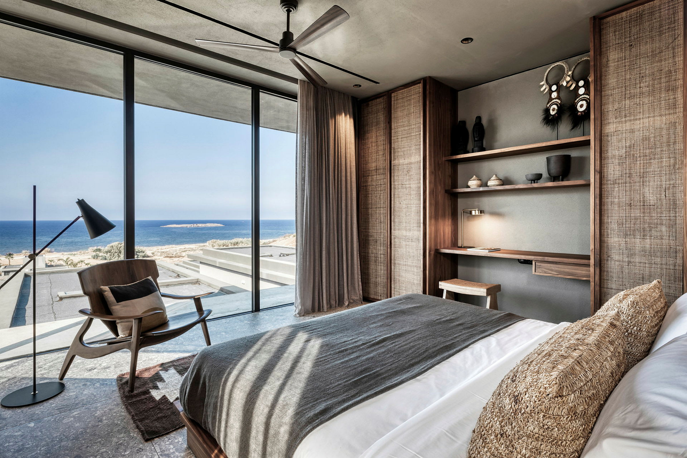 Moderne hotellrom med havutsikt gjennom store vinduer. (AI-generert tekst)