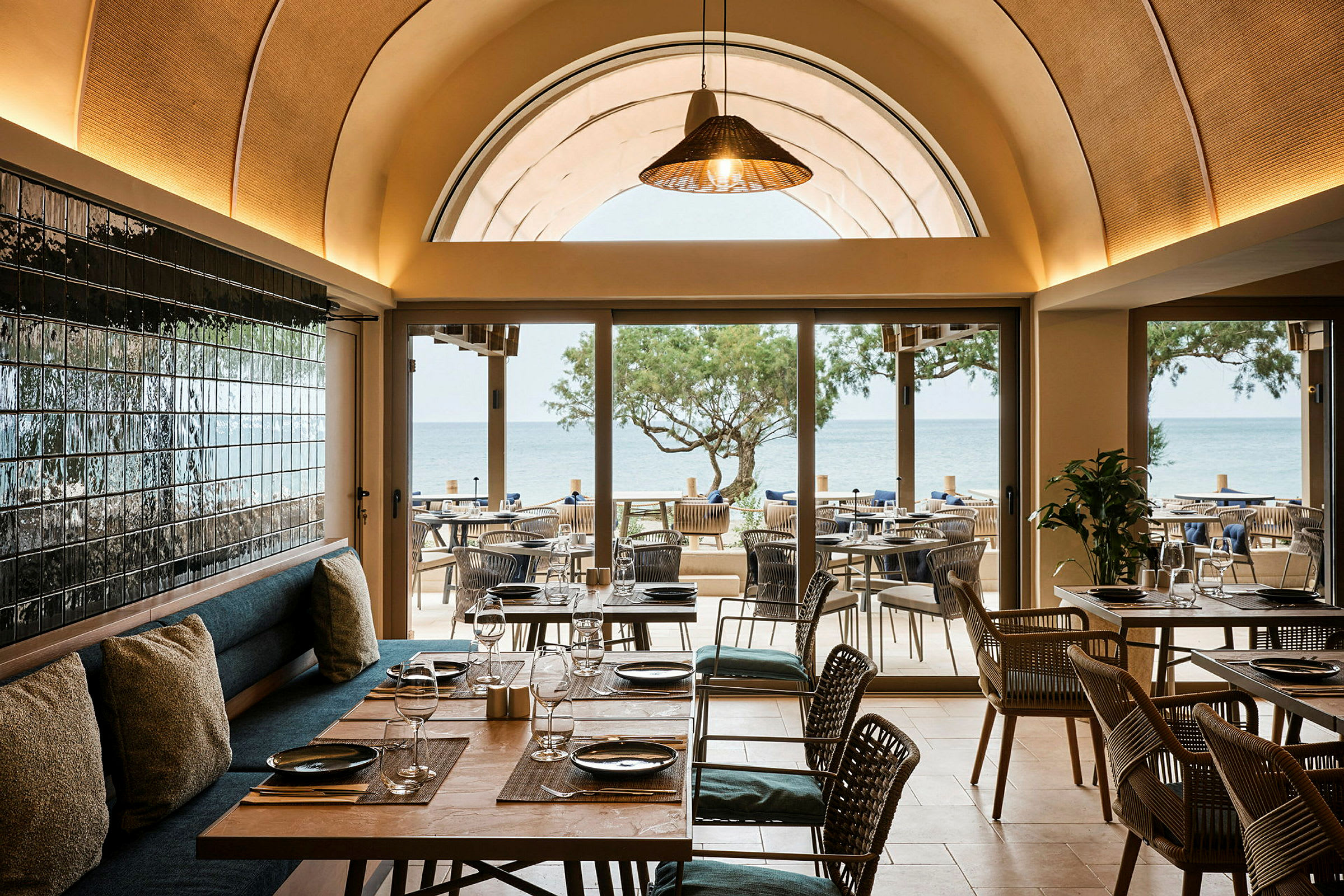 Restaurant med utsikt over havet, møbler i tre og glassdetaljer. (AI-generert tekst)