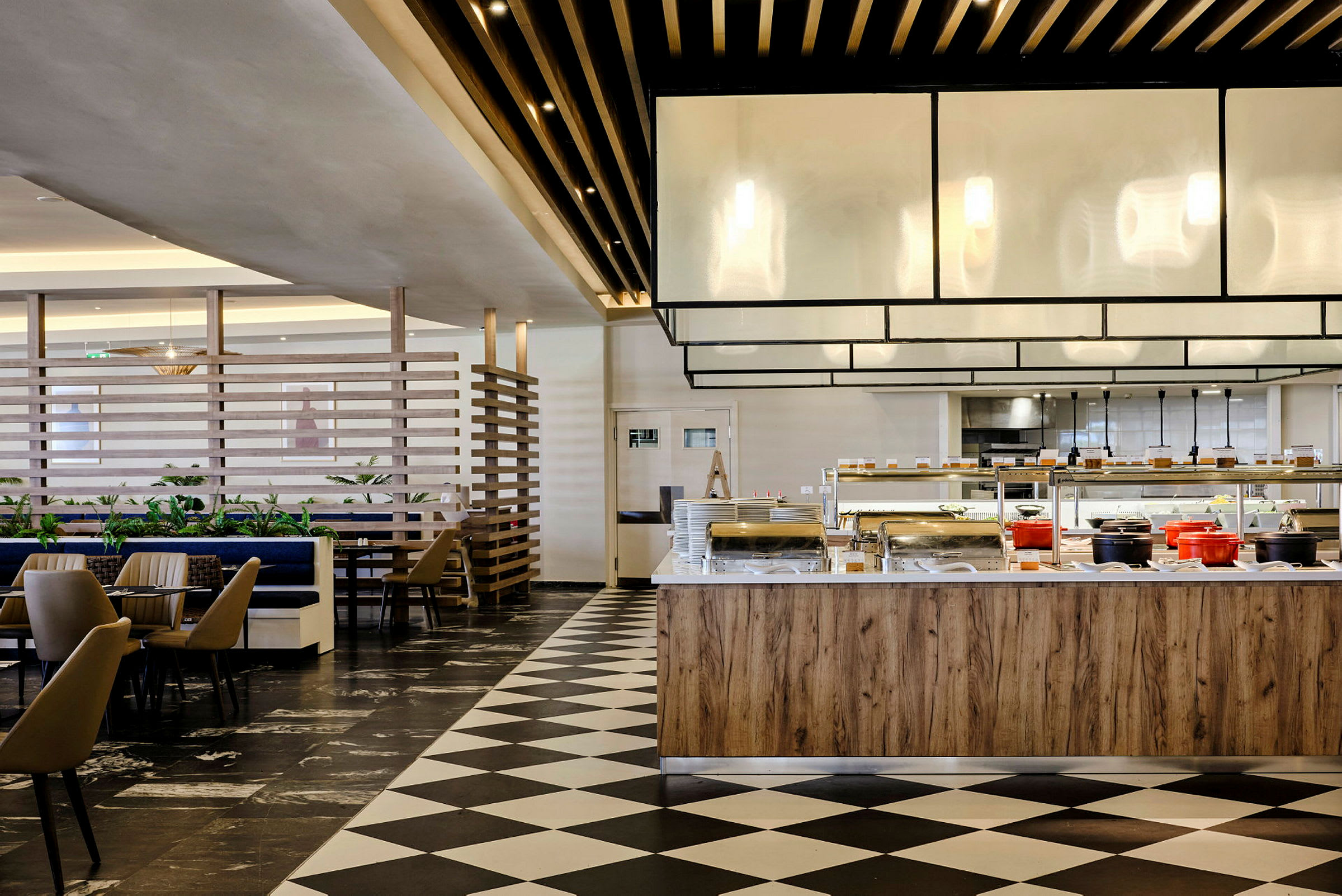 Interiør av en restaurant med buffetområde og sitteplasser. (AI-generert tekst)