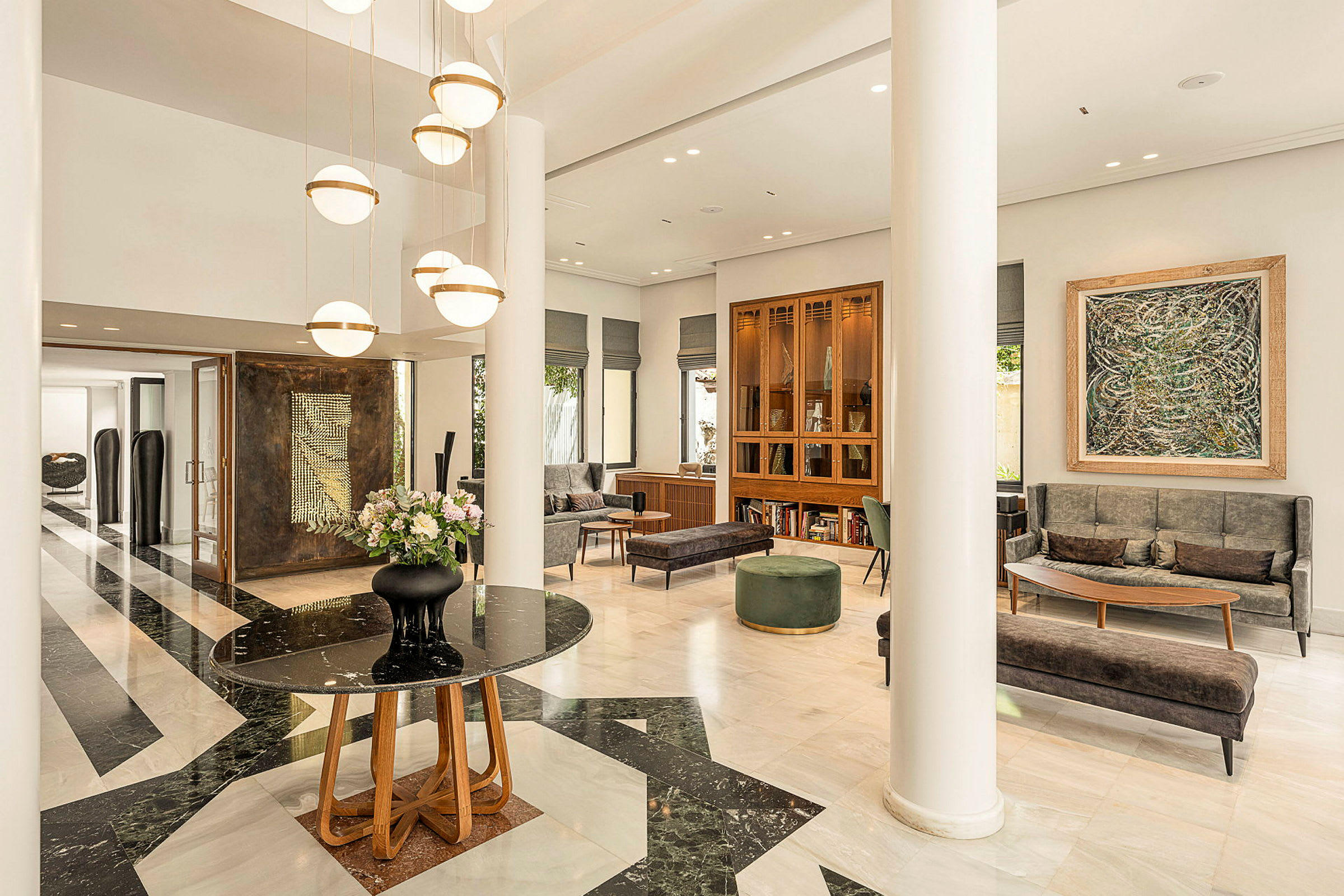 Moderne designet hotellobby med marmorgulv, lyse møbler og hengende lamper. (AI-generert tekst)