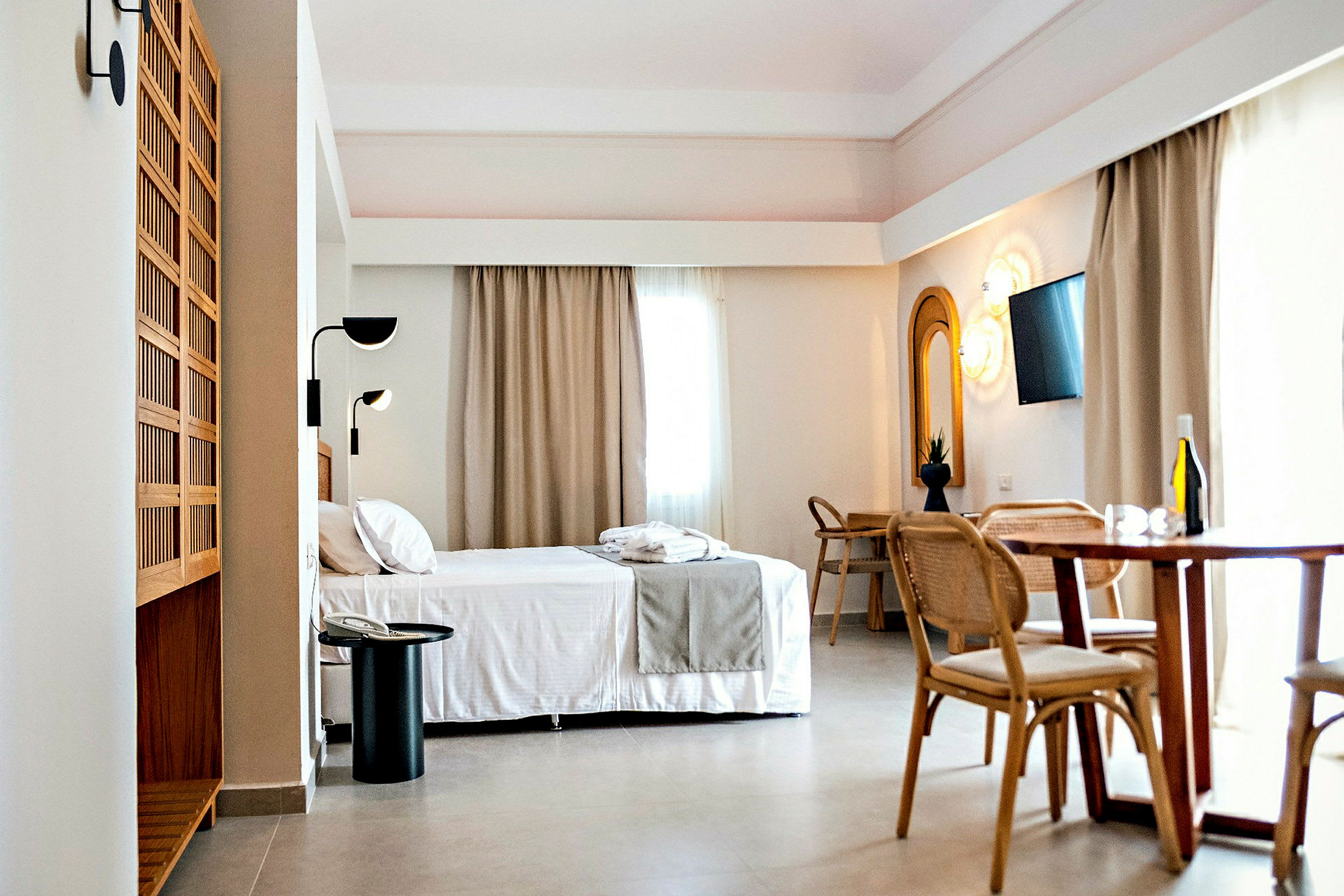 Hotellrom med seng, spisebord og skrivebord. (AI-generert tekst)