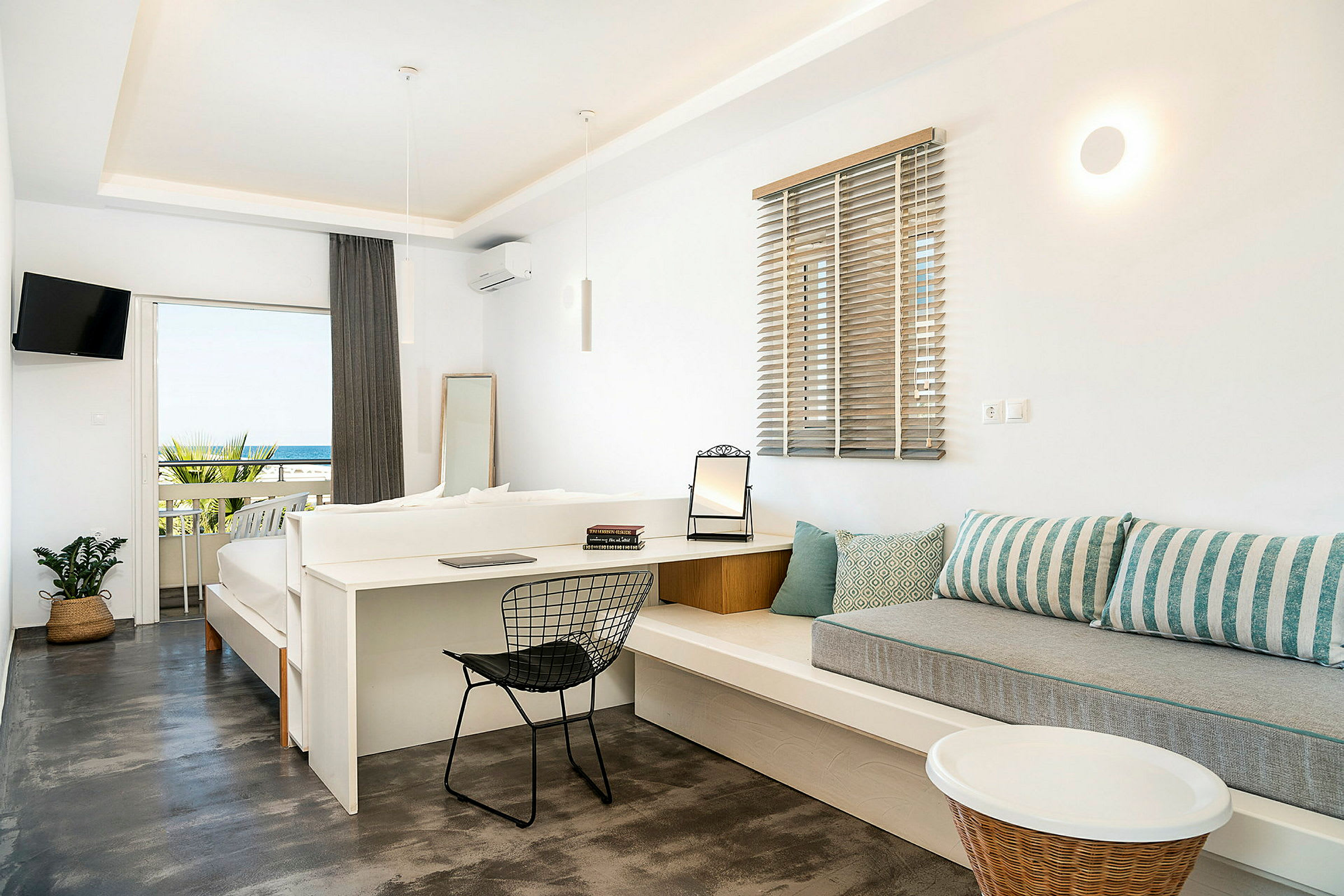 Hotellrom med lys innredning og havutsikt fra en balkong. (AI-generert tekst)