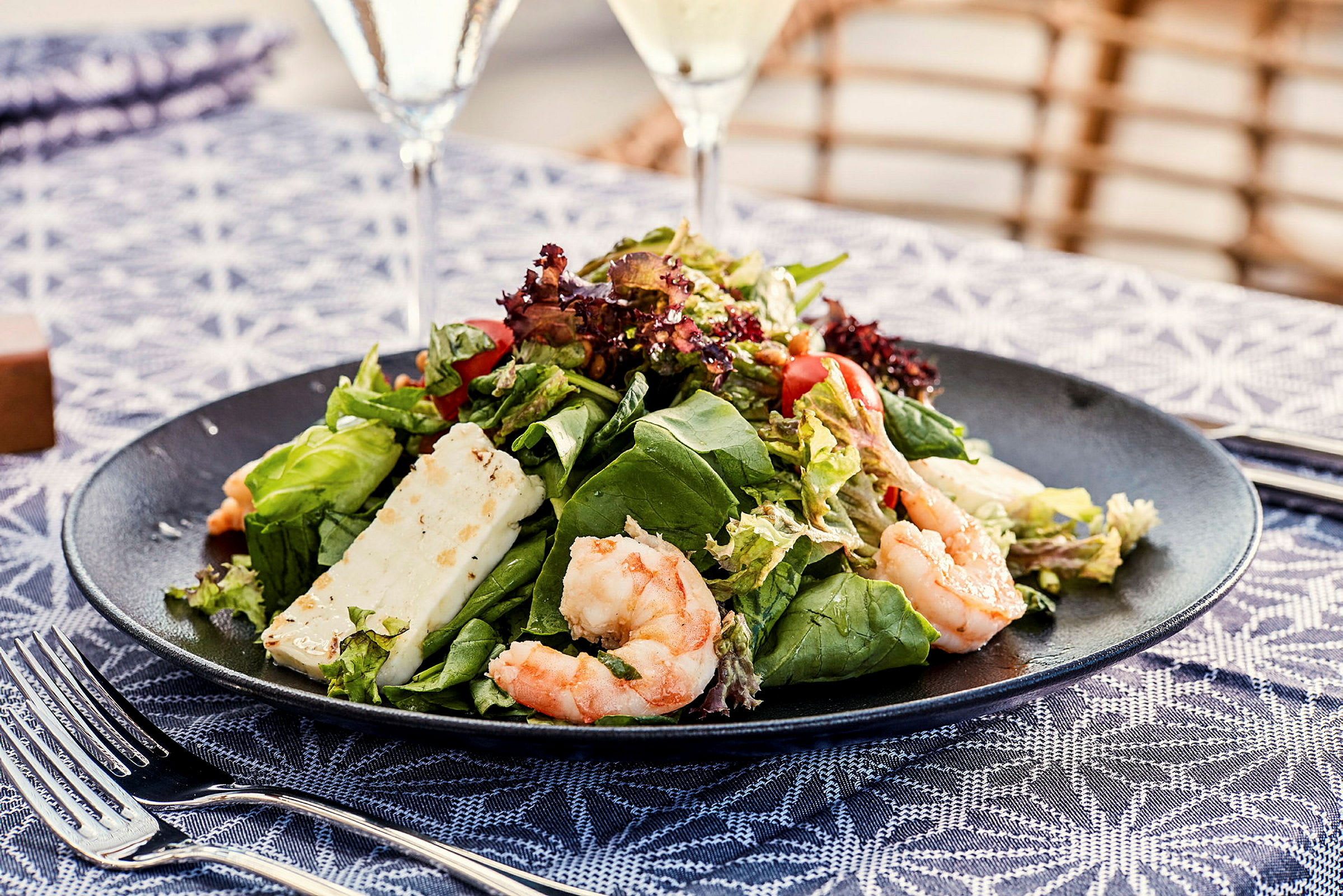 En tallerken med salat, reker og ost. (AI-generert tekst)