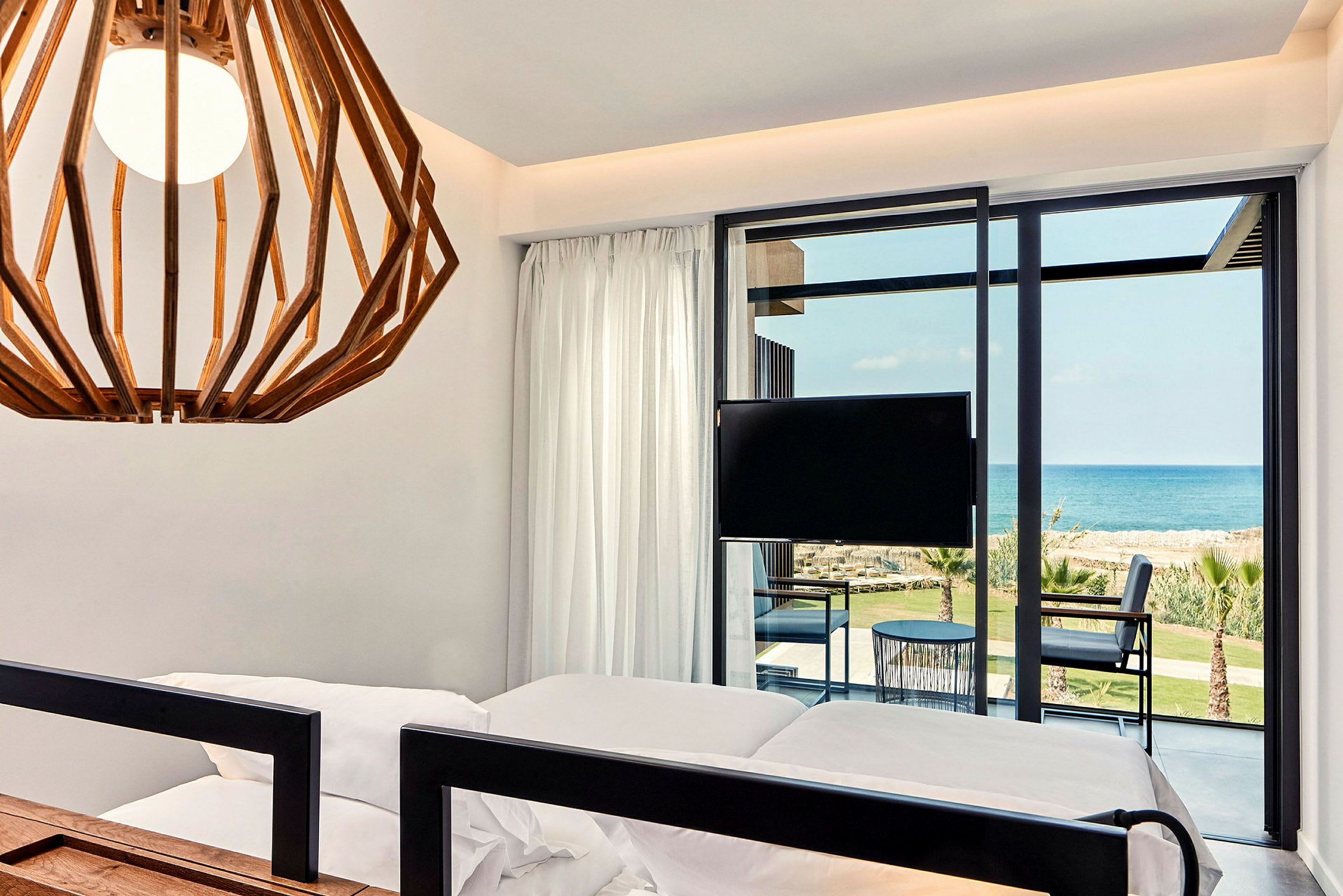 Hotellrom med moderne interiør, havutsikt og balkong. (AI-generert tekst)