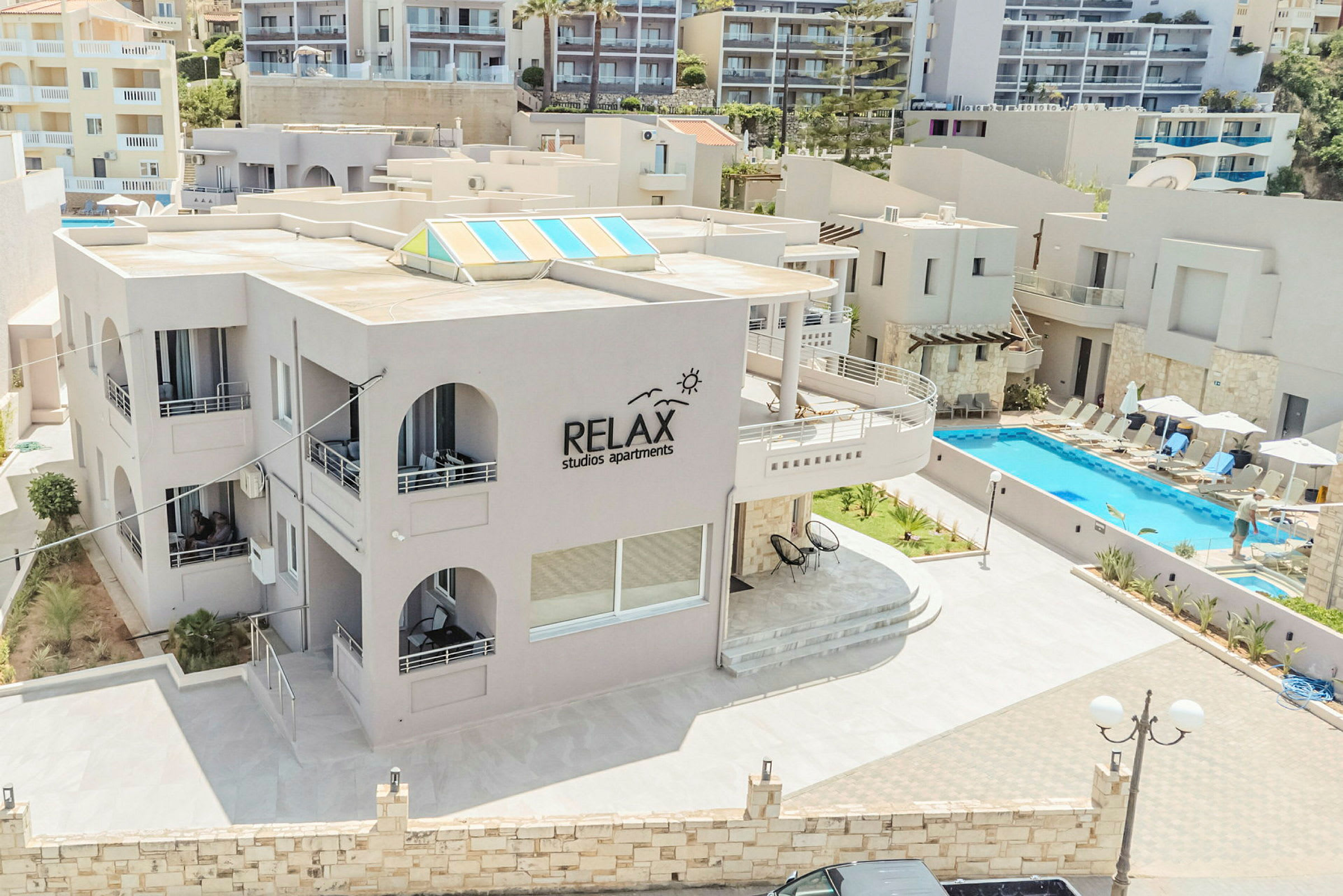 Utendørsområde ved Relax Studios Apartments, med basseng og solsenger. (AI-generert tekst)