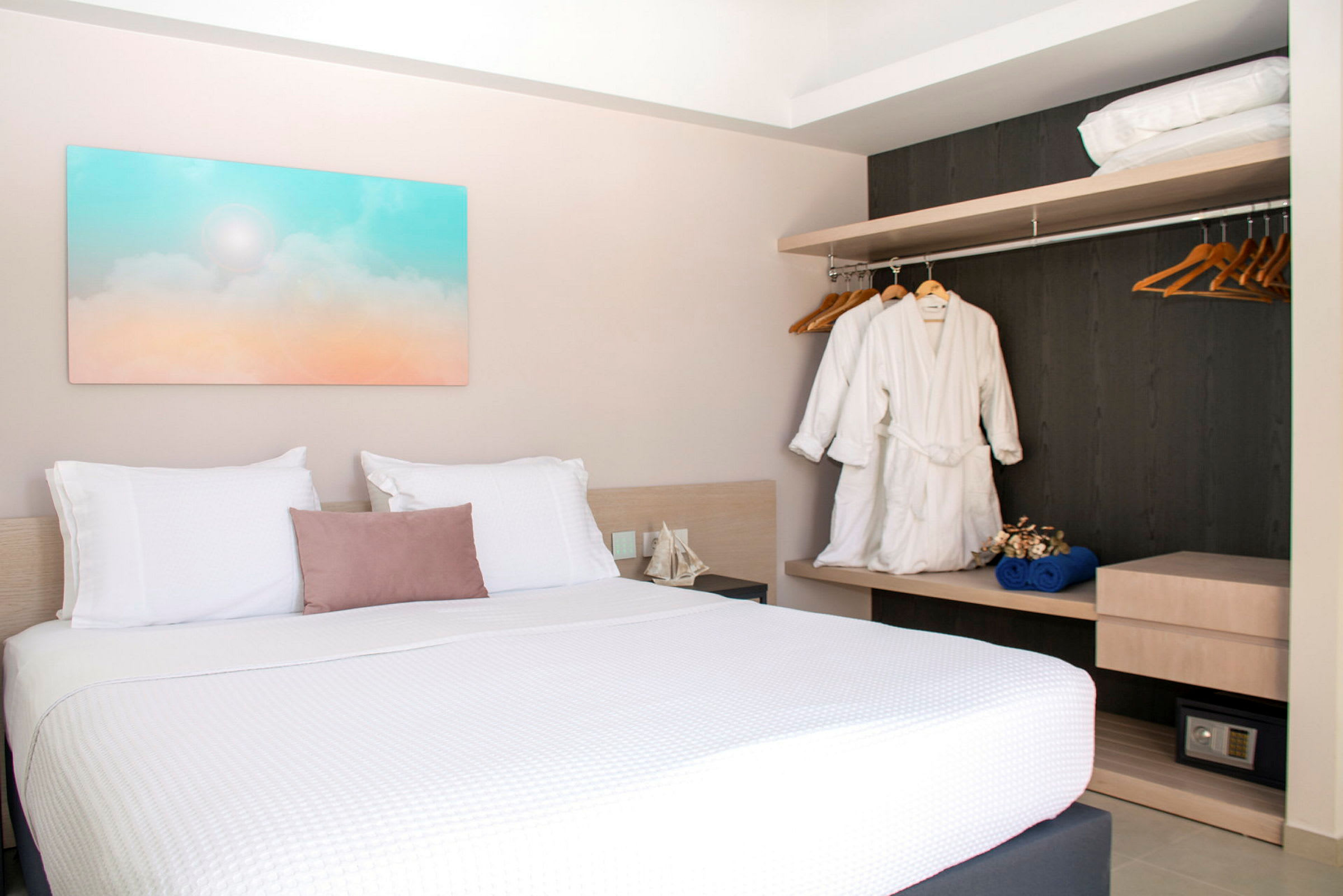 Hotellrom med dobbeltseng, veggkunst og garderobe. (AI-generert tekst)