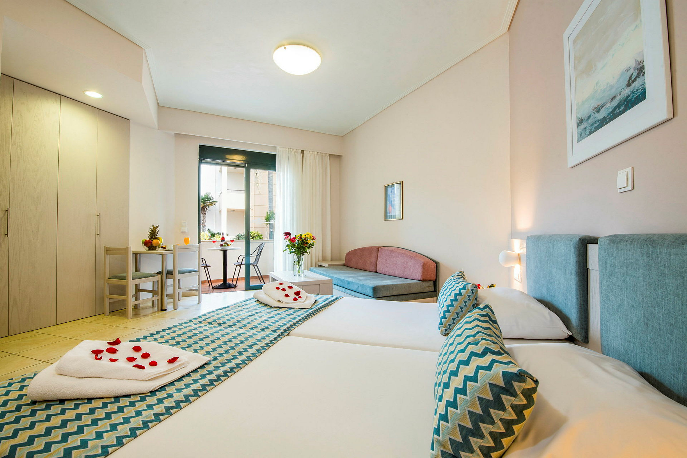 Hotellrom med to senger, sittegruppe og utgang til balkong. (AI-generert tekst)