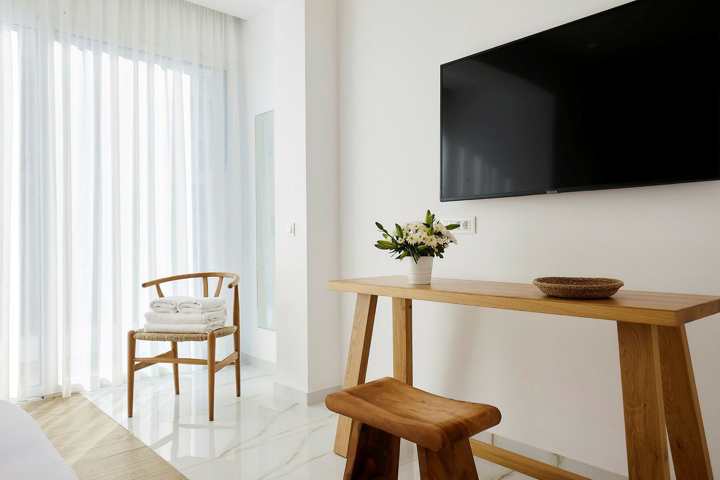 Interiør av et moderne rom med trebord, trestol og en TV på veggen. (AI-generert tekst)
