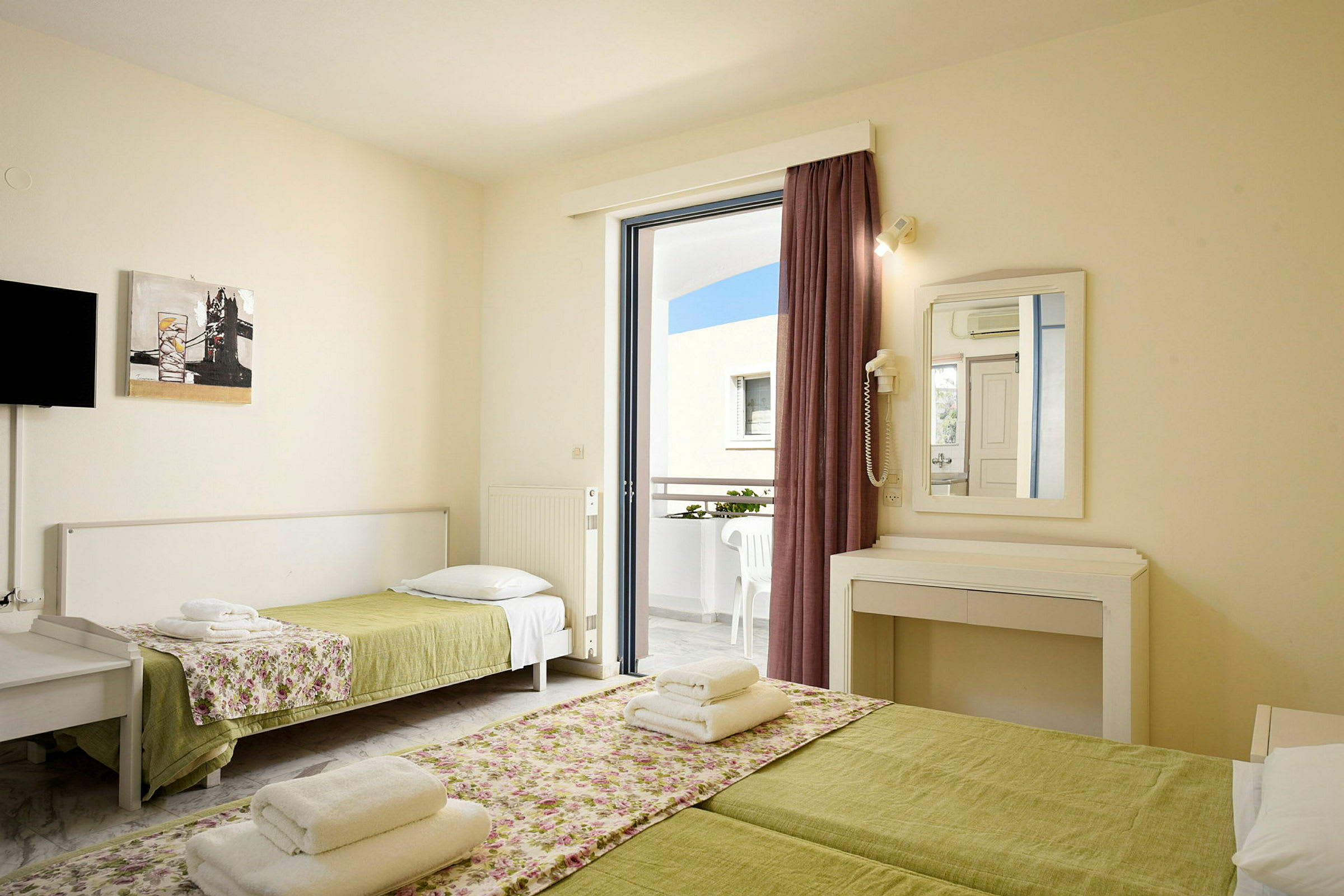 Et hotellrom med to senger og en balkong. (AI-generert tekst)