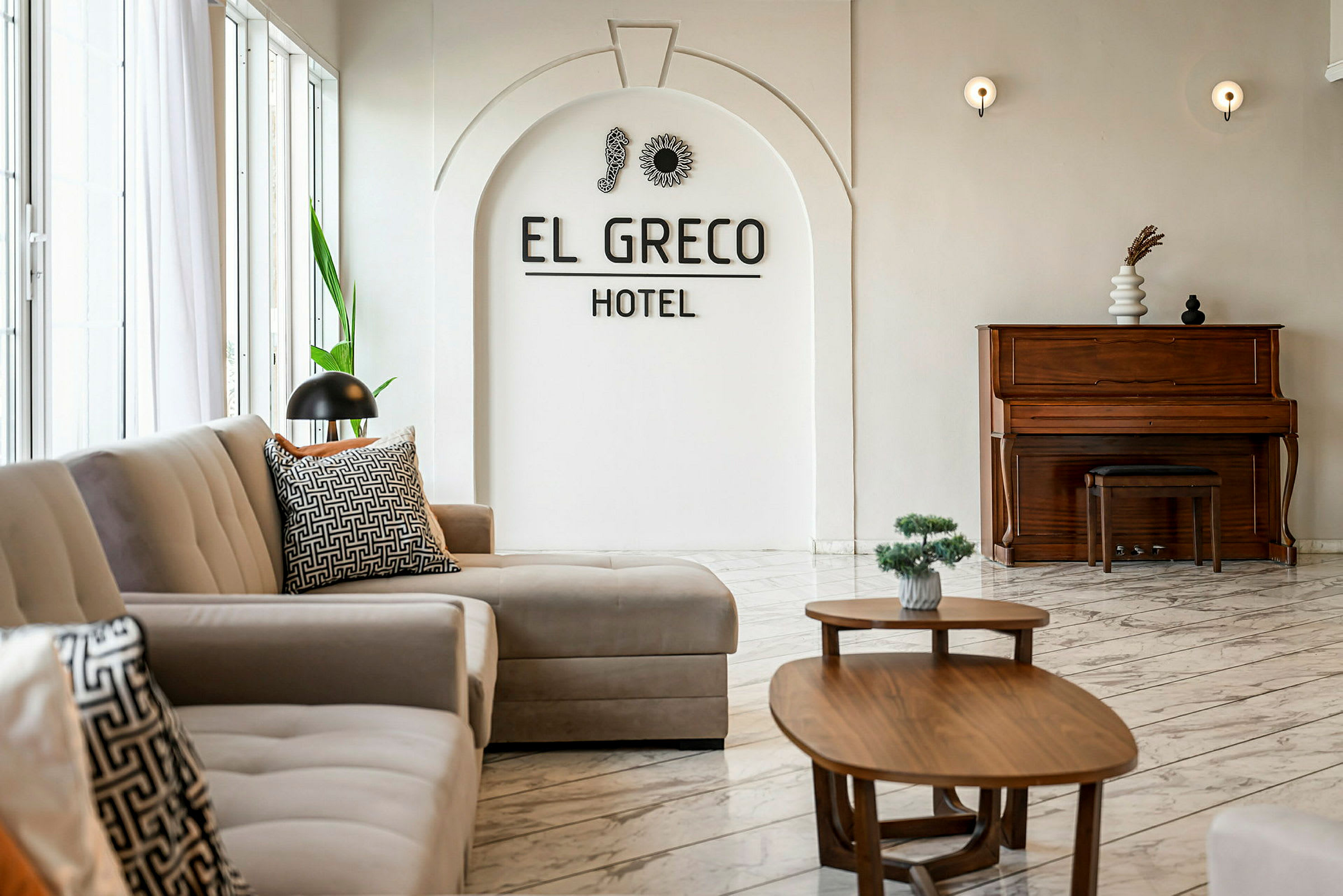 Interiør av et hotell med sofaer, bord og et piano. (AI-generert tekst)