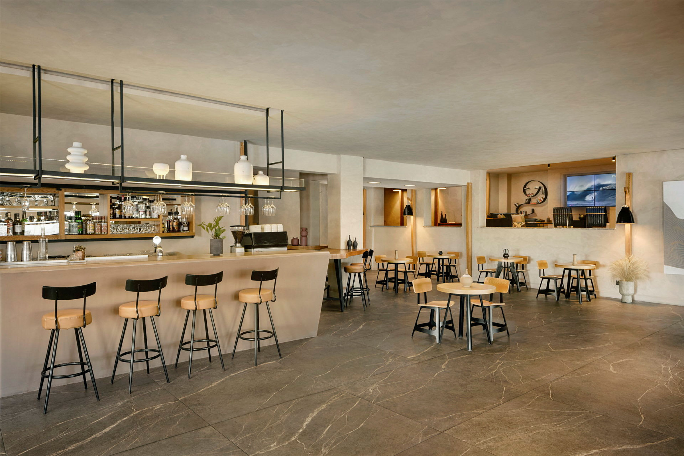 Interiør av en moderne bar og kafé med bord og stoler. (AI-generert tekst)