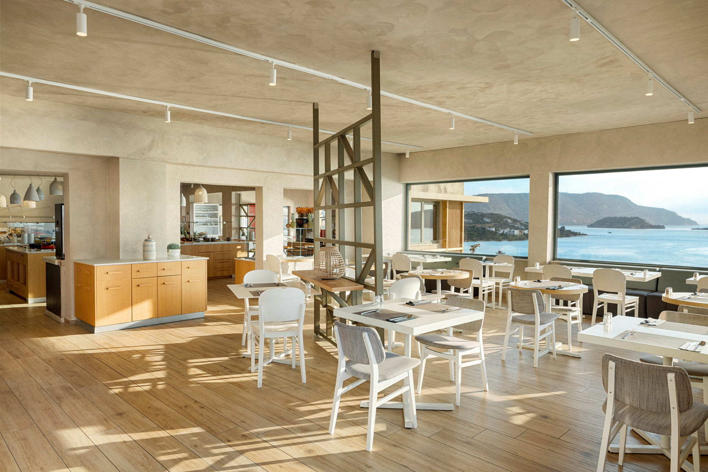 Moderne restaurantområde med store panoramavinduer og sjøutsikt. (AI-generert tekst)