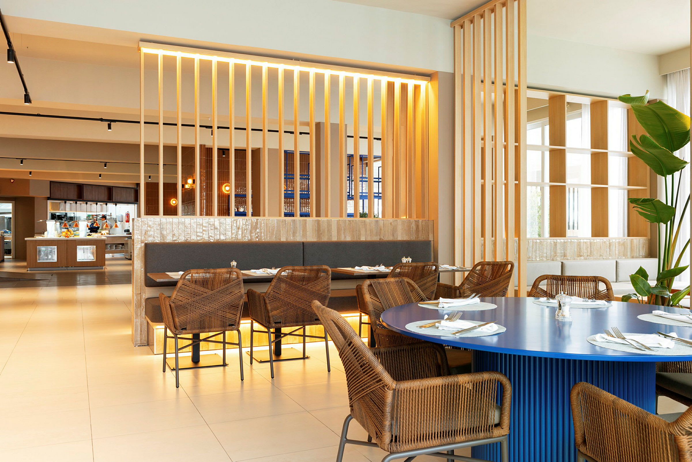 Interiør av en restaurant med rottingstoler og bord med duker. (AI-generert tekst)