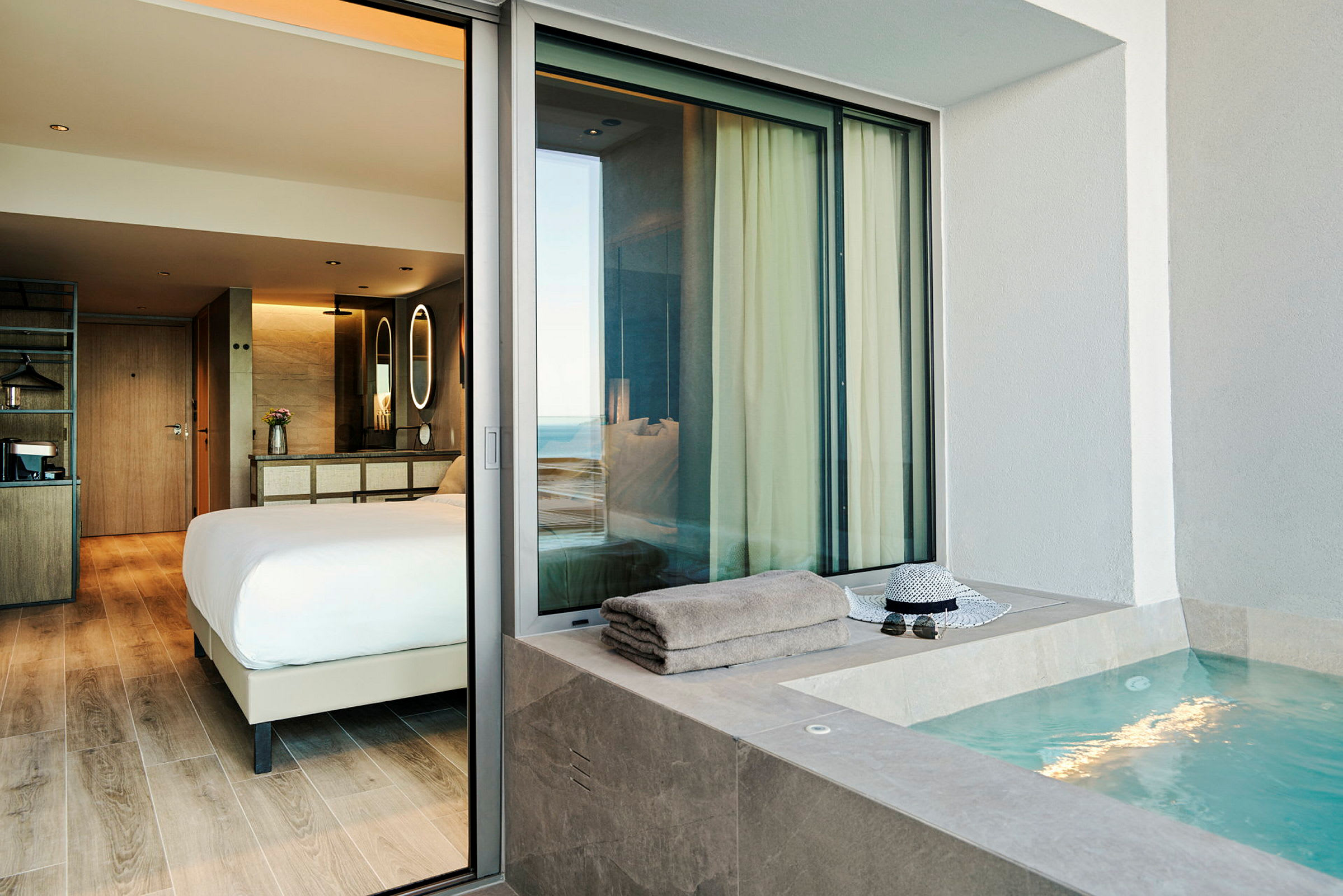 En hotellsuite med et soverom og et utendørs boblebad. (AI-generert tekst)