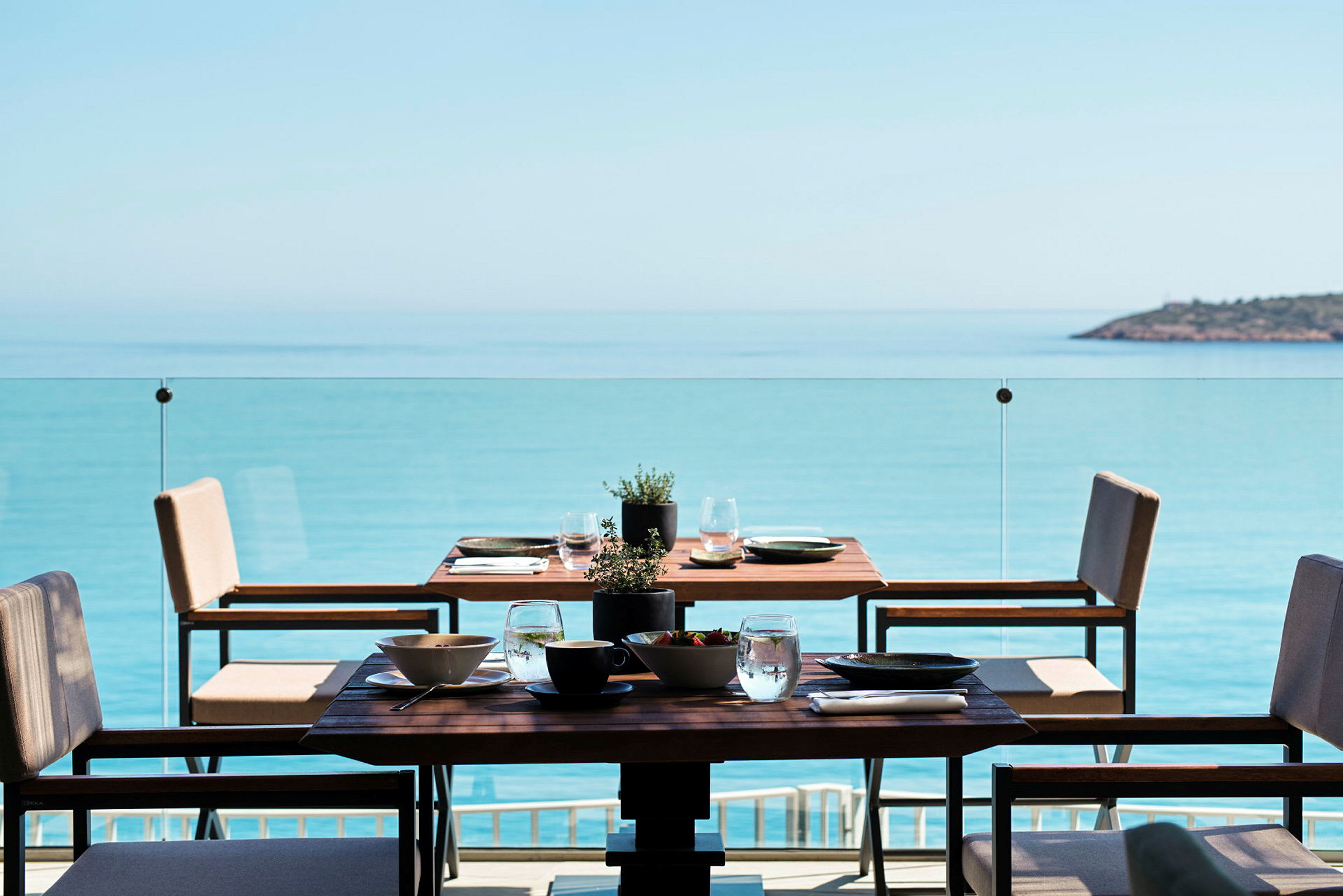 Et dekket bord på en terrasse med utsikt over havet. (AI-generert tekst)