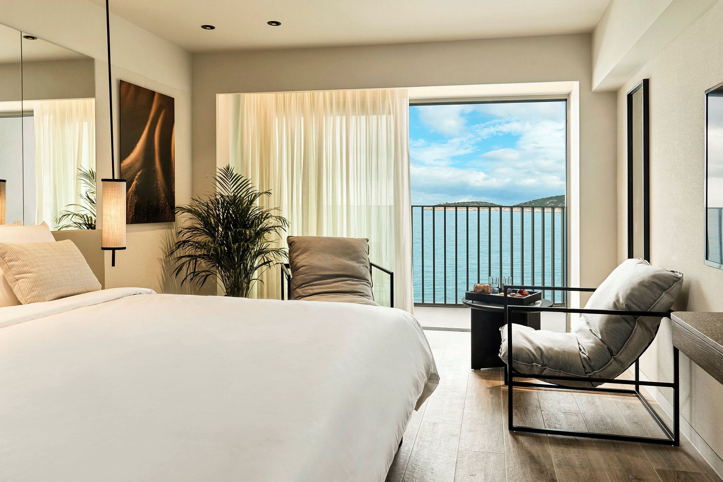 Elegant hotellrom med havutsikt gjennom stort vindu. (AI-generert tekst)
