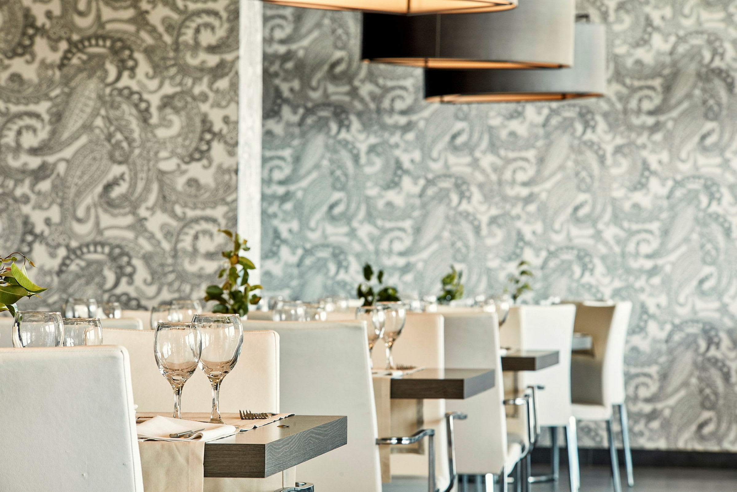 Restaurant med hvite stoler og dekkede bord. (AI-generert tekst)