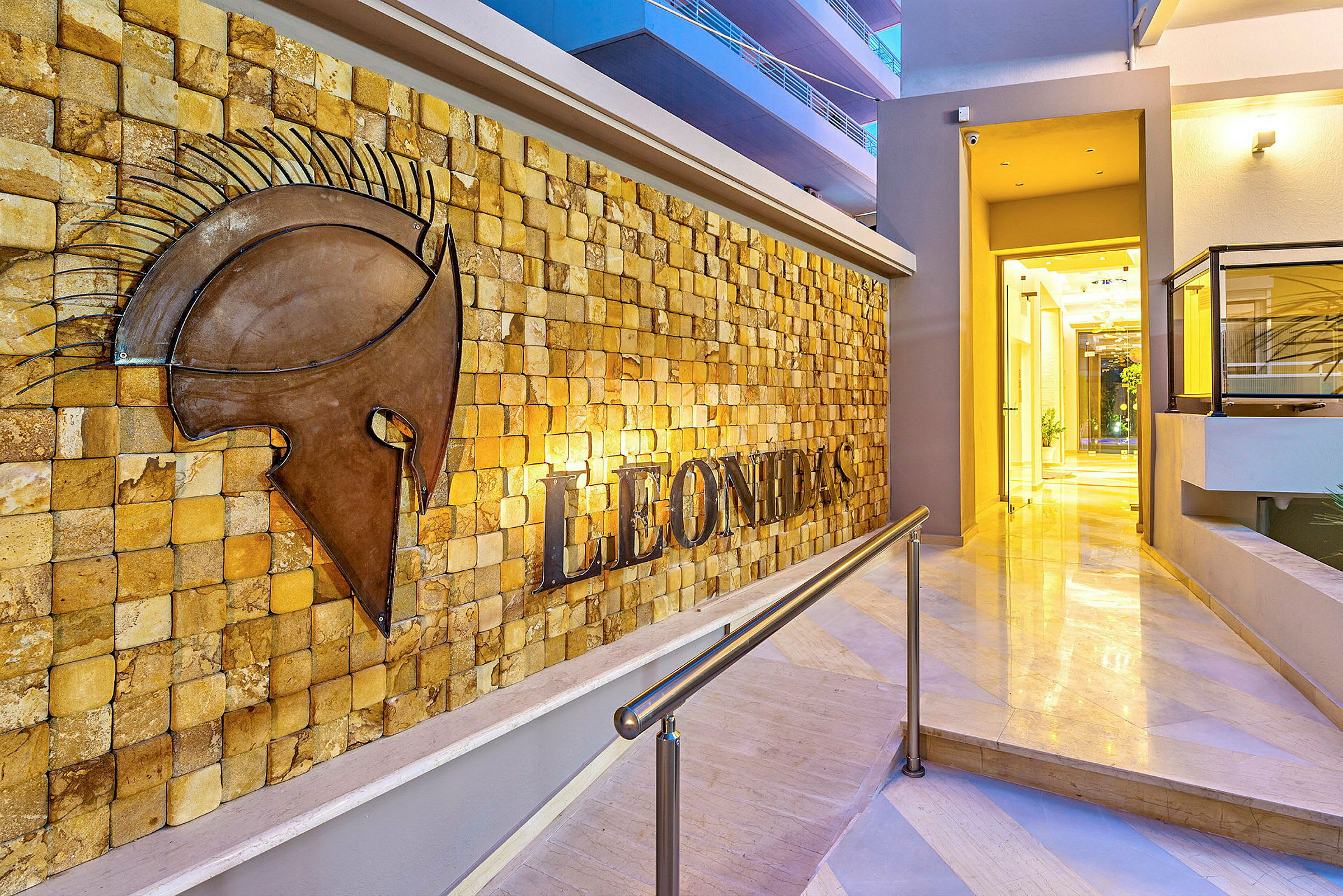 Inngang til Leonidas hotell med en veggdekorasjon av en hjelm. (AI-generert tekst)