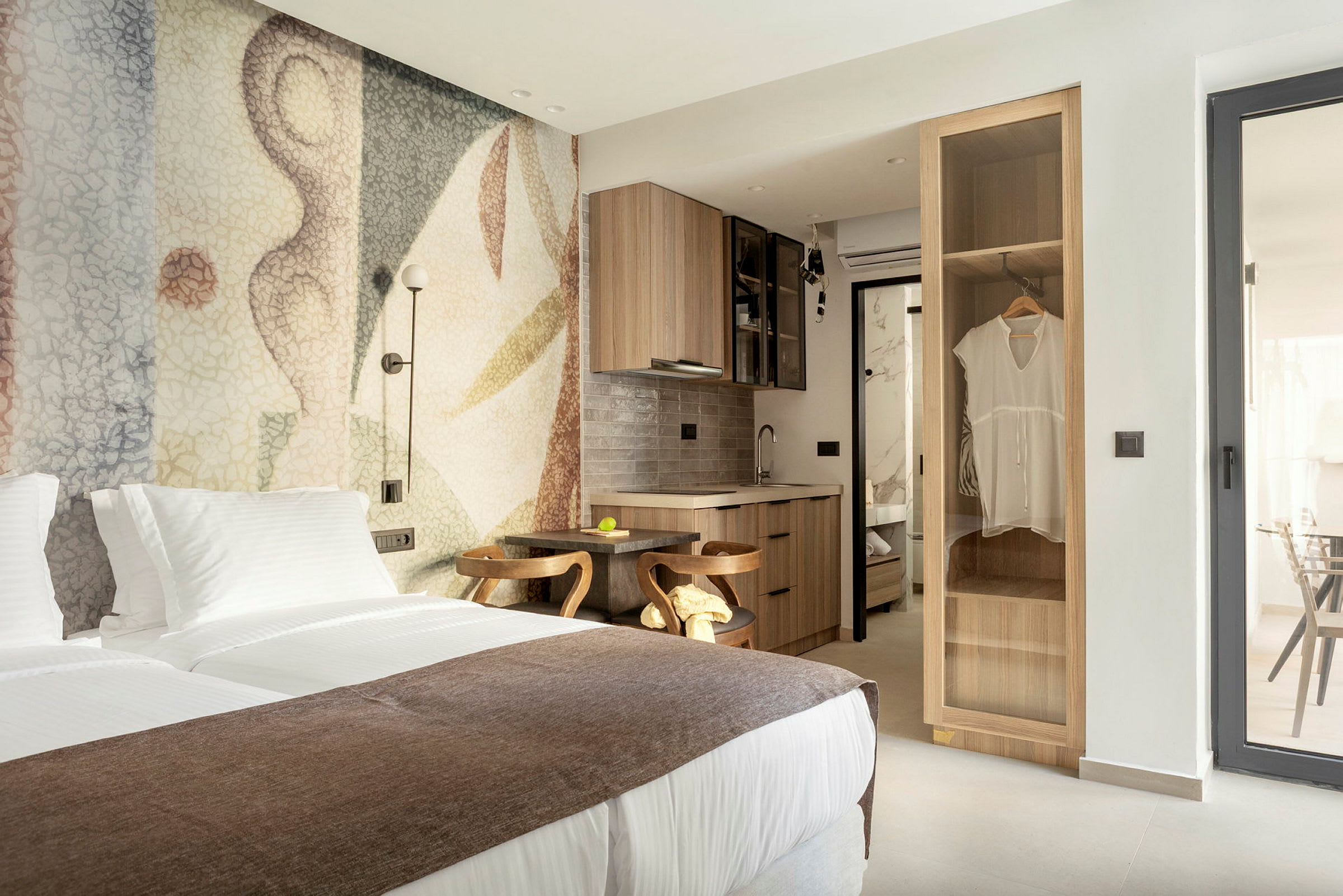 Moderne hotellrom med dobbeltseng, koselig interiør og en liten kjøkkenkrok. (AI-generert tekst)