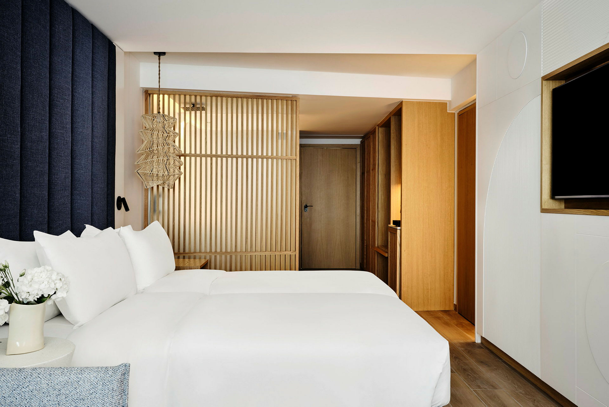 Bilde av et moderne hotellrom med en seng med hvitt sengetøy og tredetaljer. (AI-generert tekst)