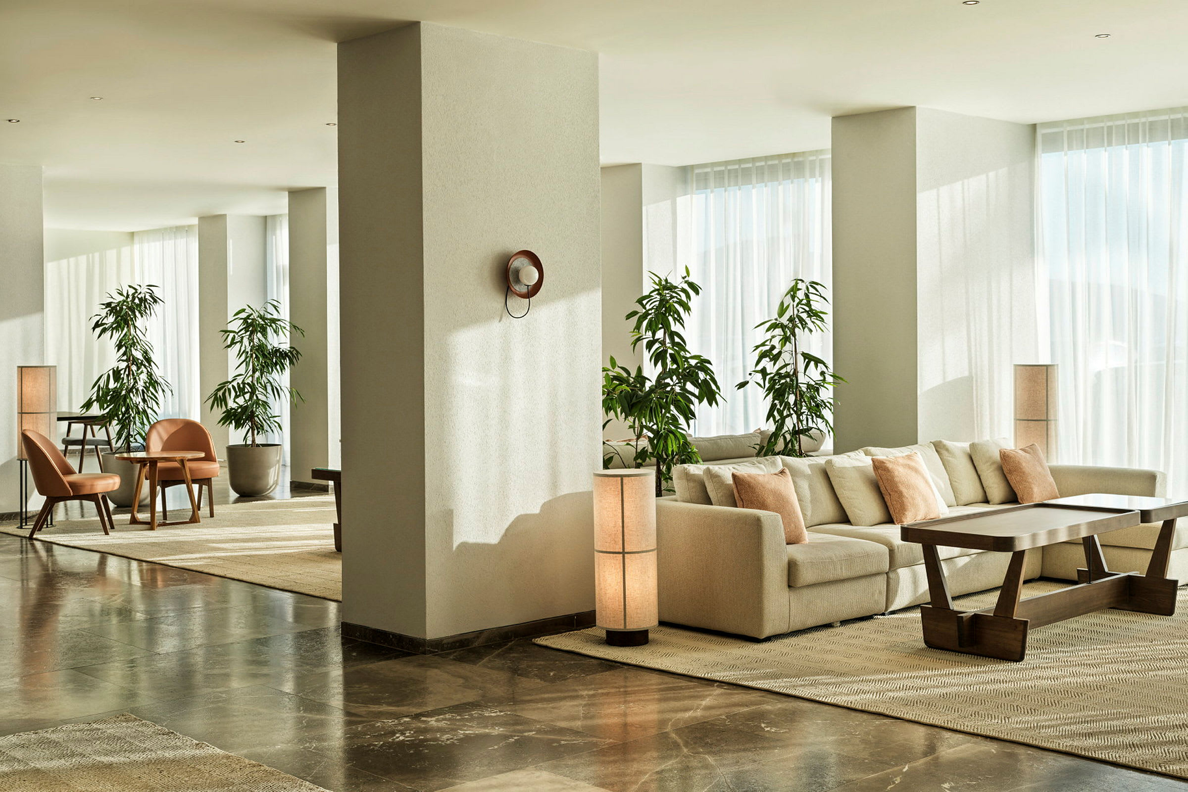 Moderne hotellrom med sofagruppe og grønne planter. (AI-generert tekst)