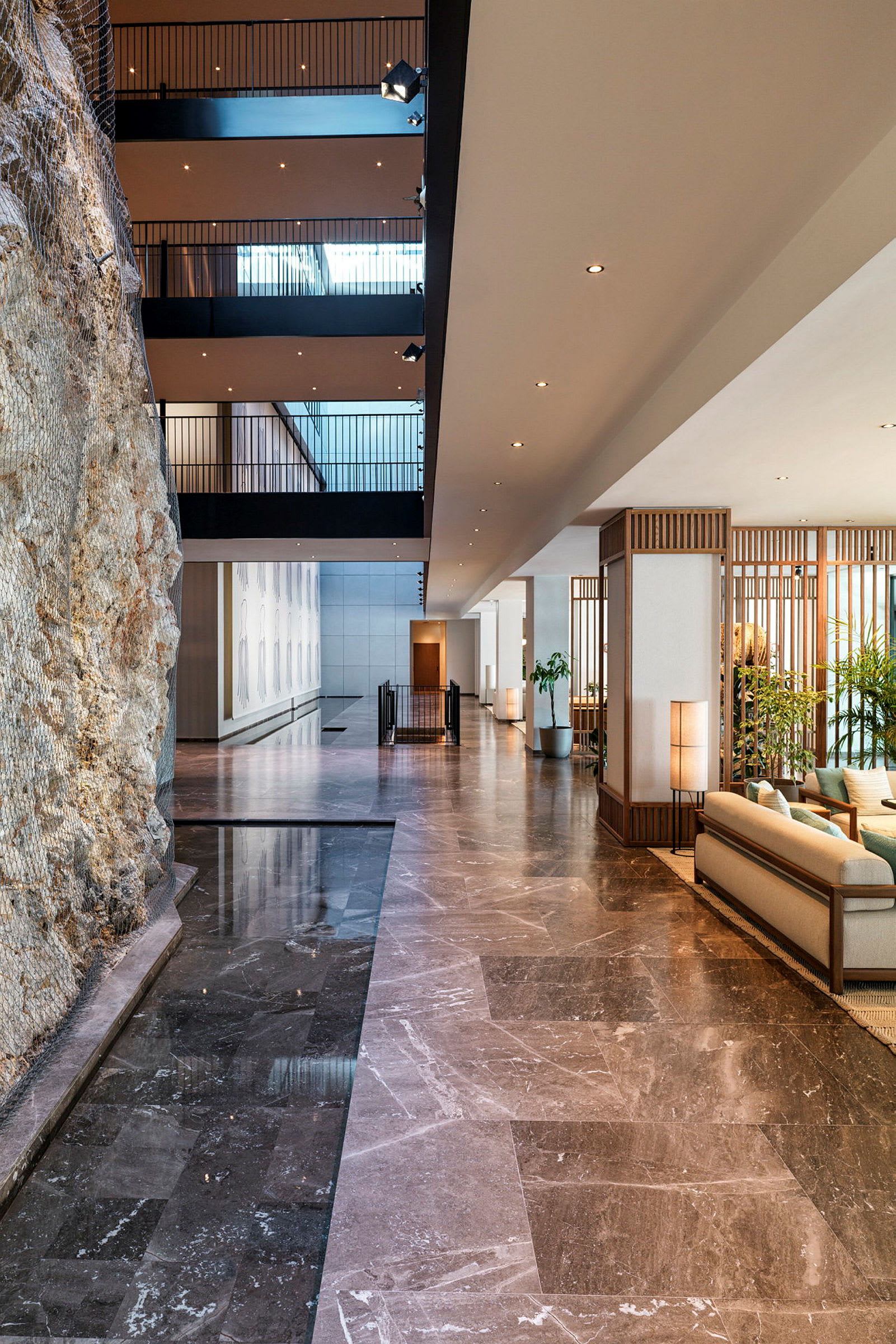 Interiør av en elegant hotellobby med marmor, sittemøbler og dekorative elementer. (AI-generert tekst)