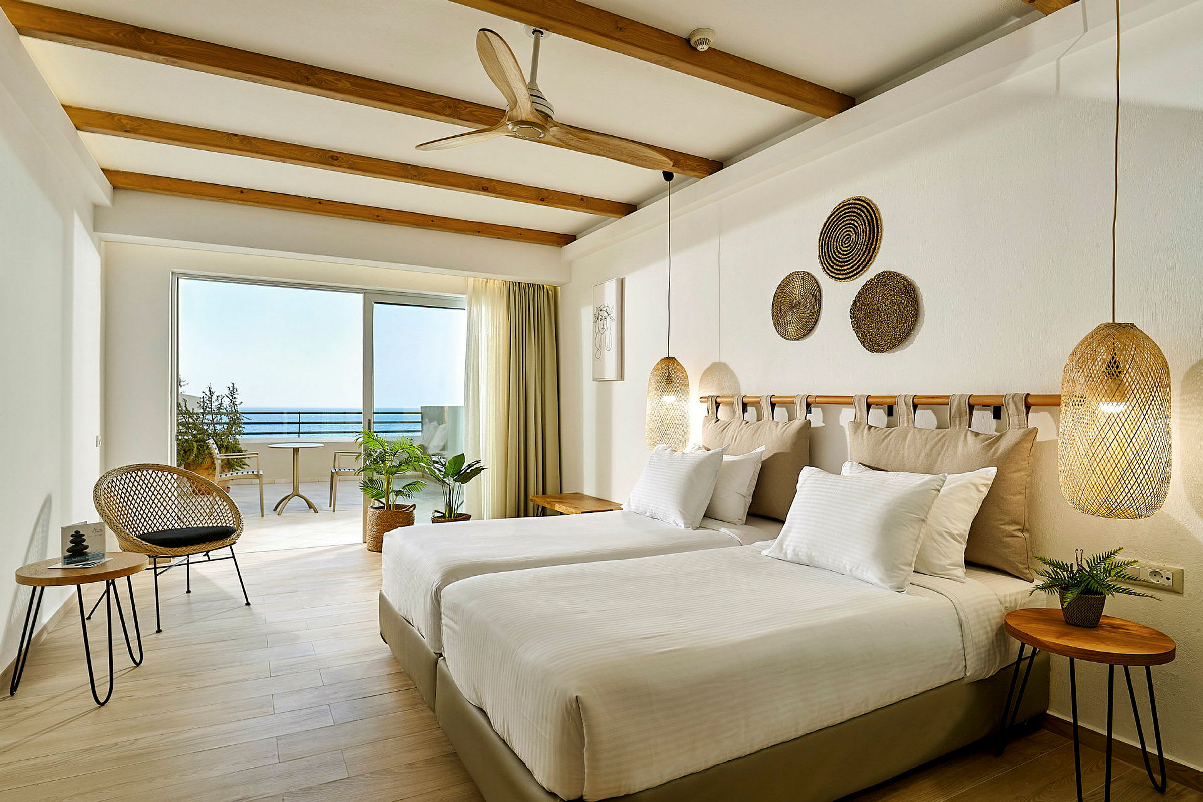 Lyst og moderne hotellrom med to enkeltsenger og havutsikt. (AI-generert tekst)