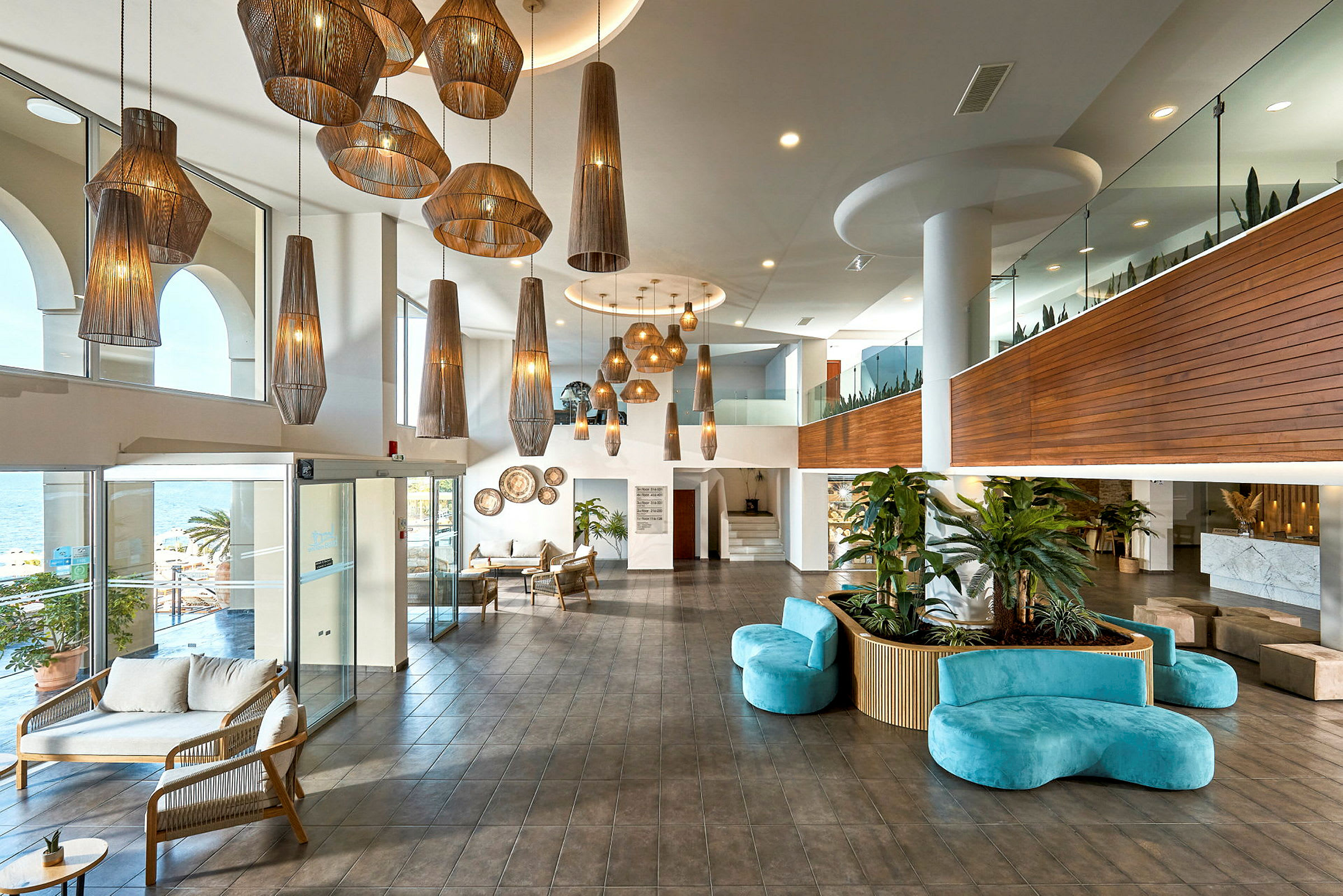 En moderne hotellobby med store hengelamper, sittemøbler og grønne planter. (AI-generert tekst)