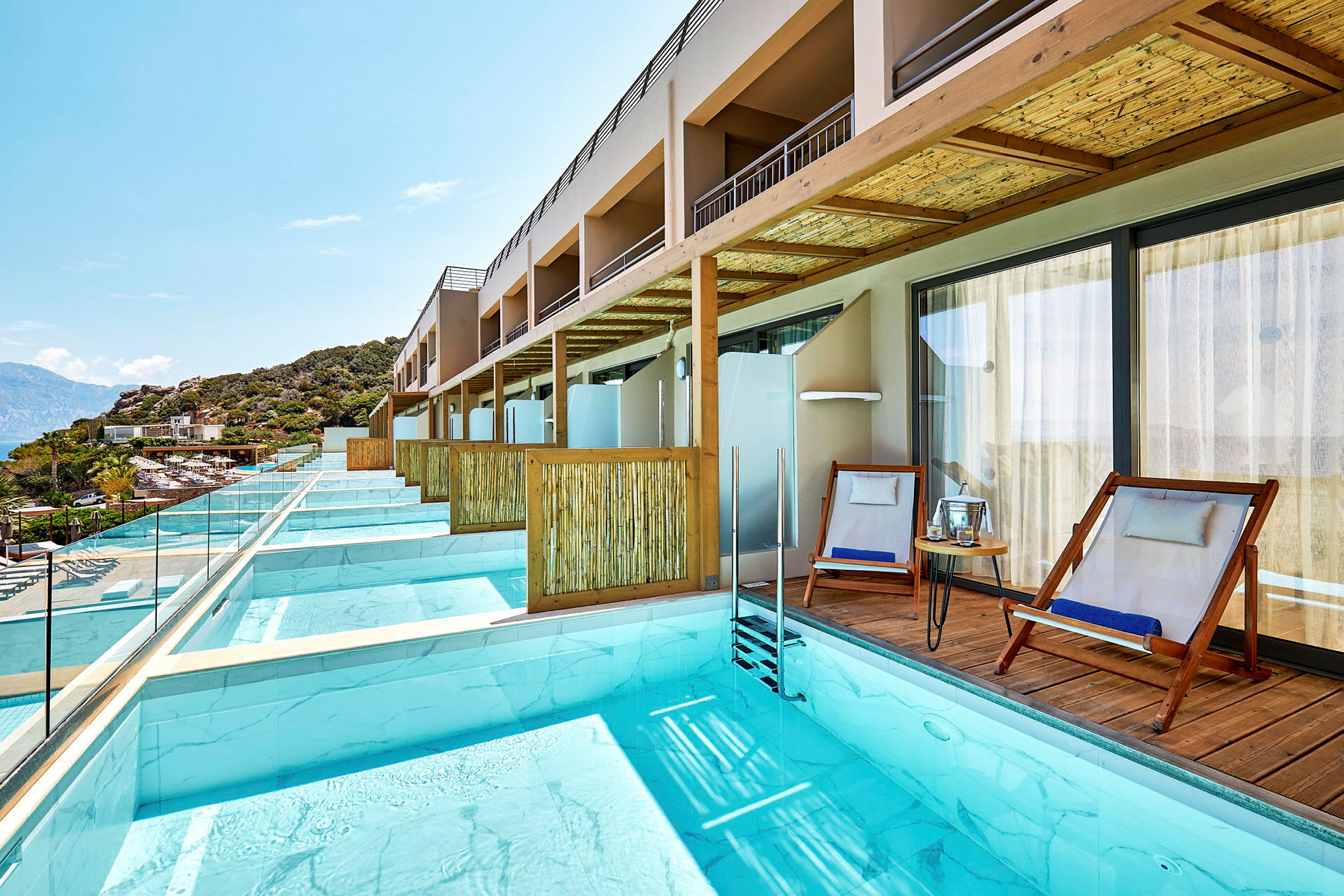 Privat bassengområde med solsenger ved en rekke hotellrom. (AI-generert tekst)