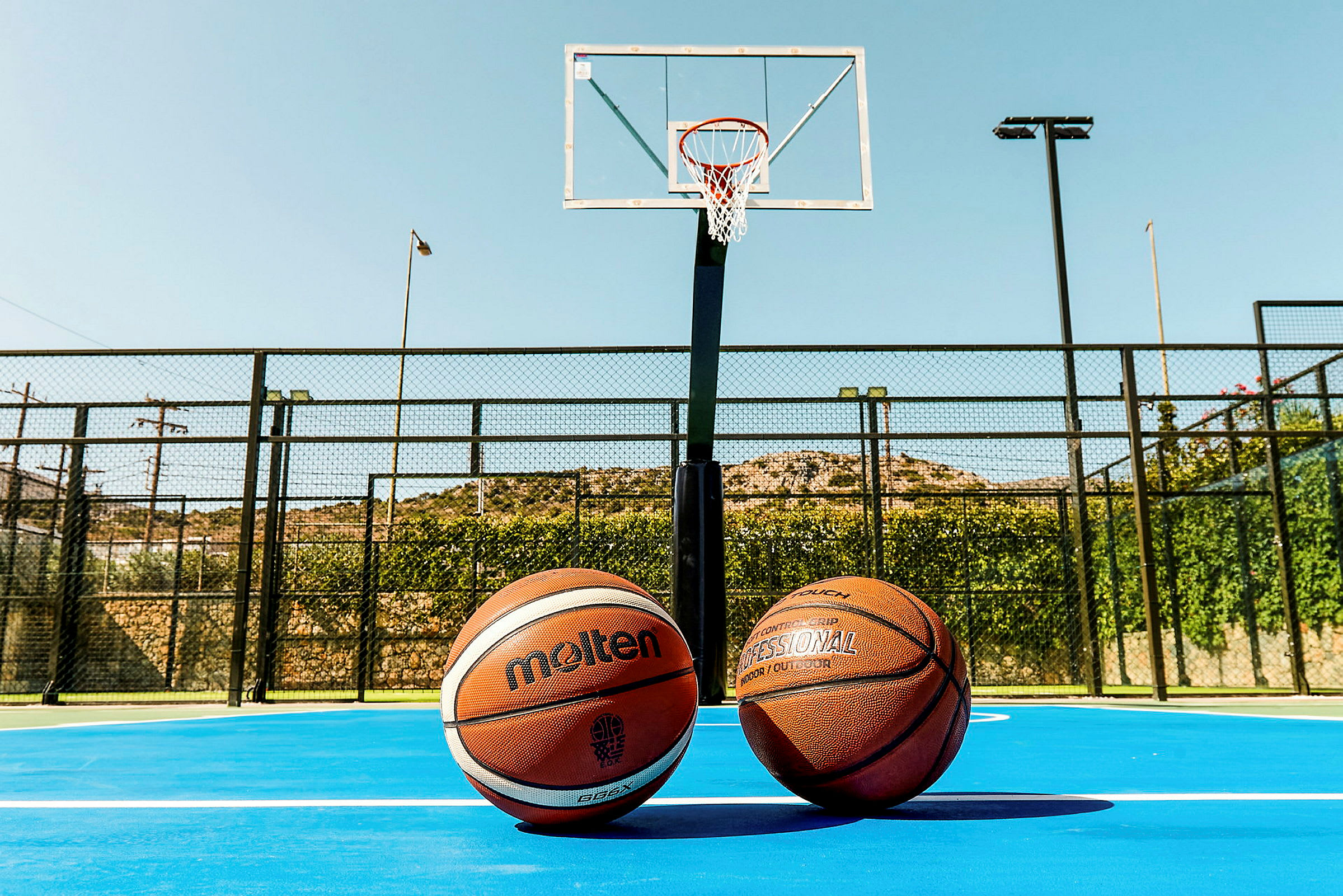 To basketballer på en basketballbane foran en basketballkurv. (AI-generert tekst)