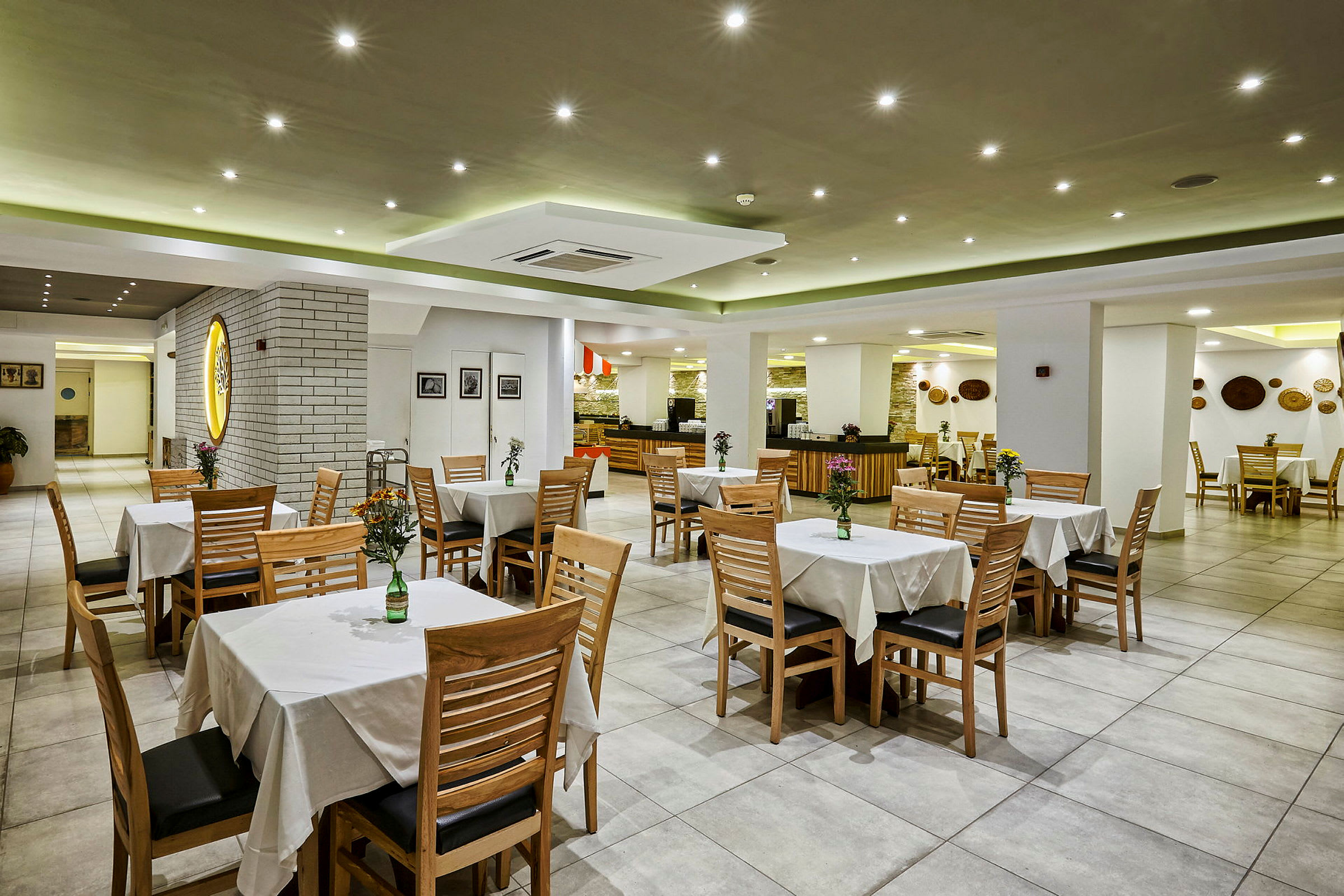 Restaurantmiljø med bord og stoler, dekorert med vaser og blomster. (AI-generert tekst)
