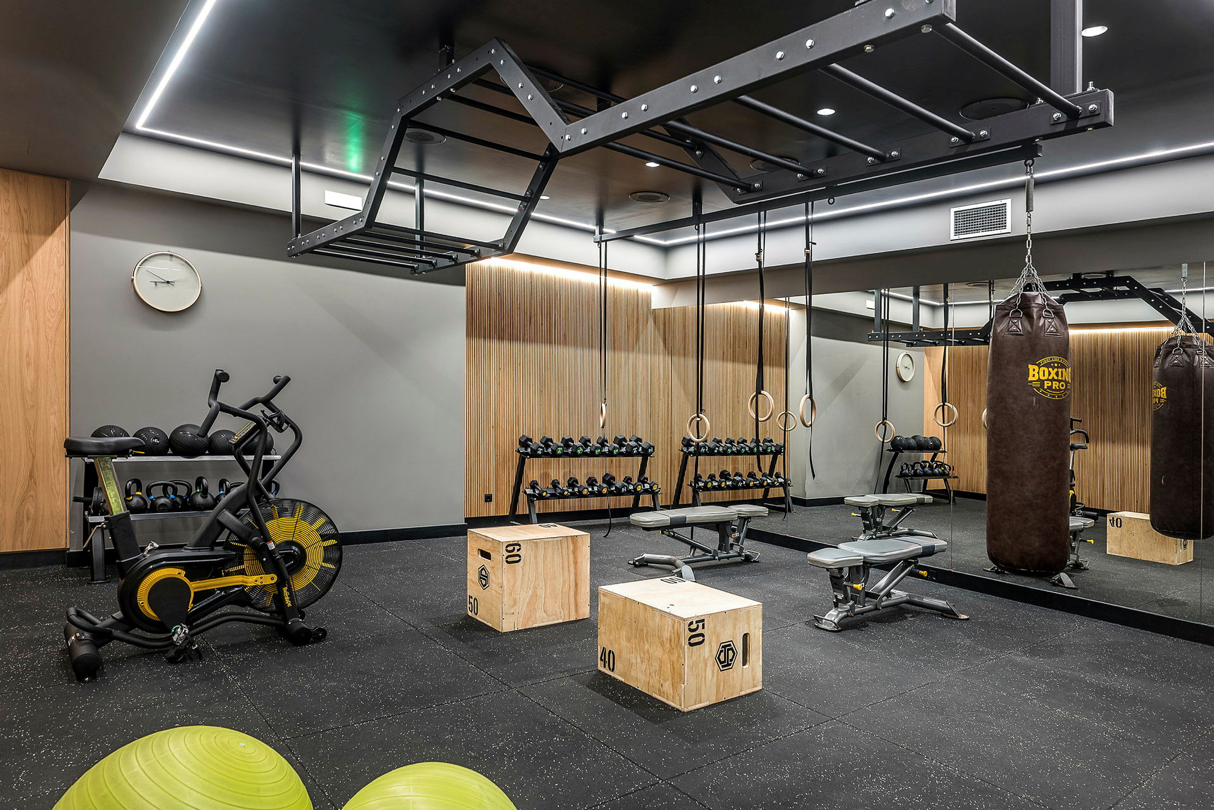Et treningsstudio med treningsutstyr, inkludert boksesekk, manualer og pilatesballer. (AI-generert tekst)
