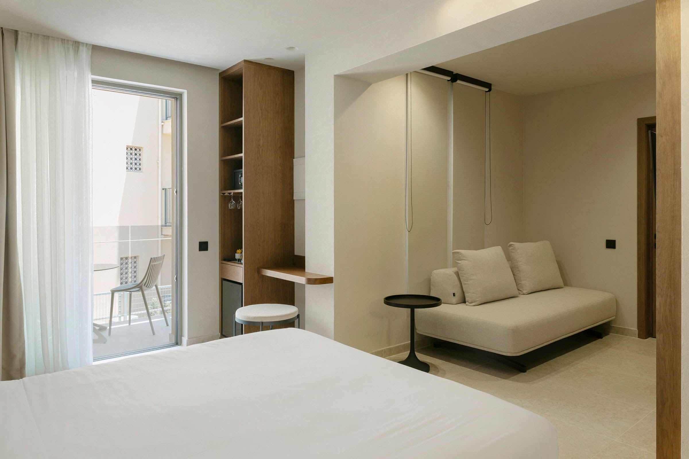 Moderne hotellrom med sittegruppe og balkong. (AI-generert tekst)