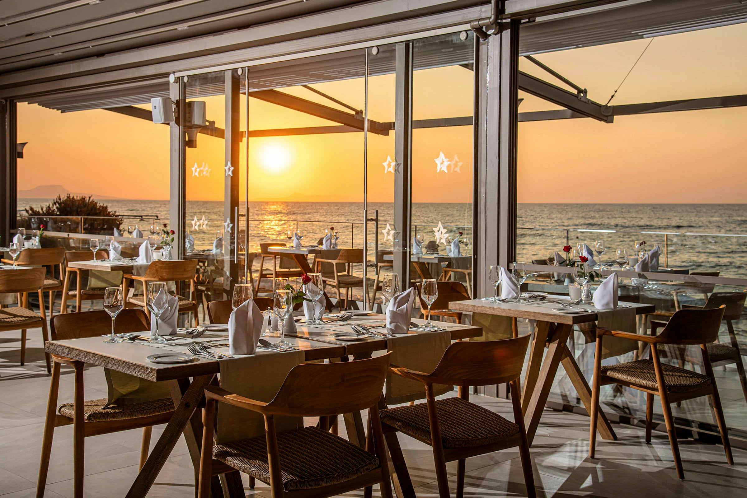 Restaurant med sjøutsikt i solnedgangen. (AI-generert tekst)
