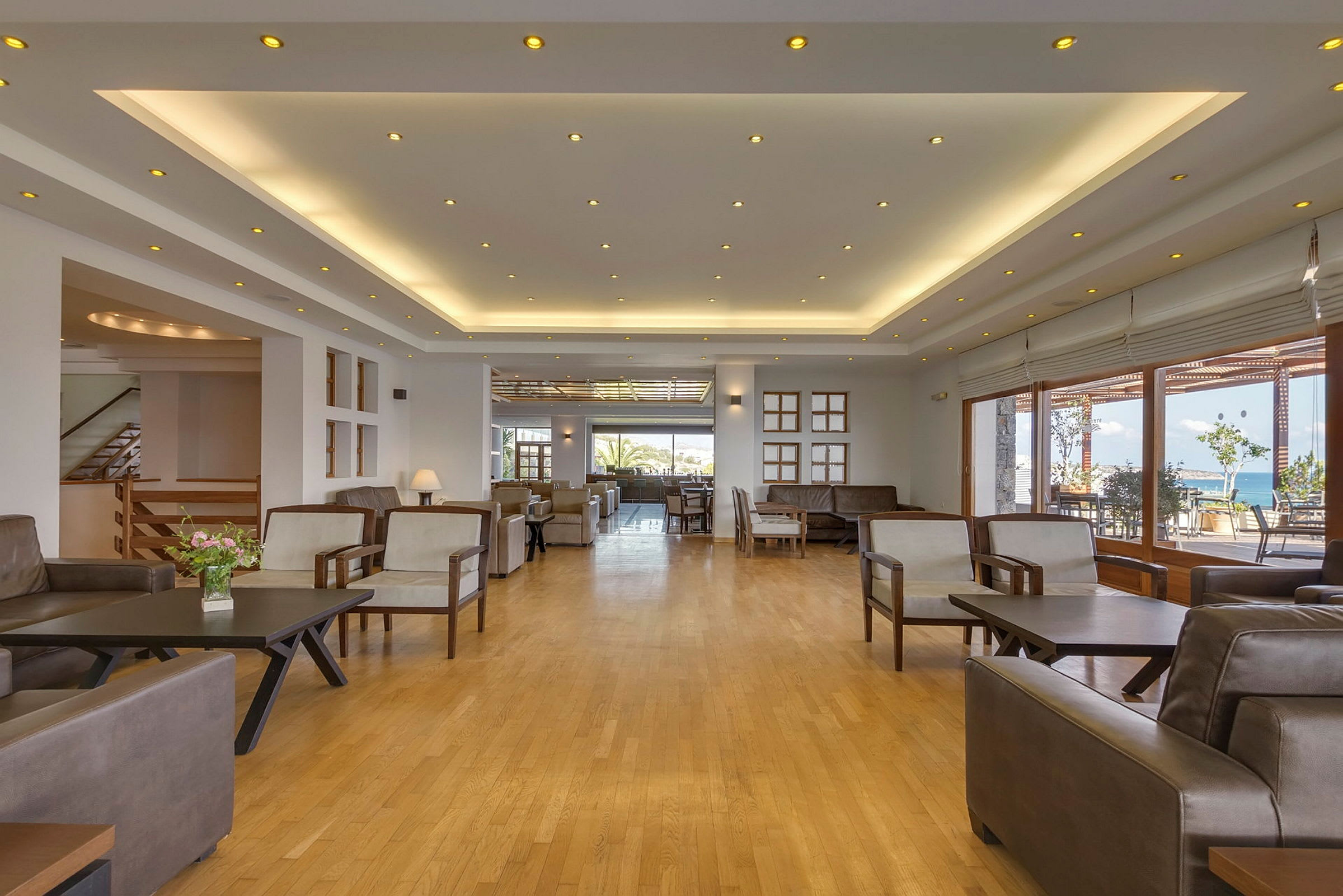 Hotellobby med moderne møbler og vinduer som vender mot utsikt. (AI-generert tekst)