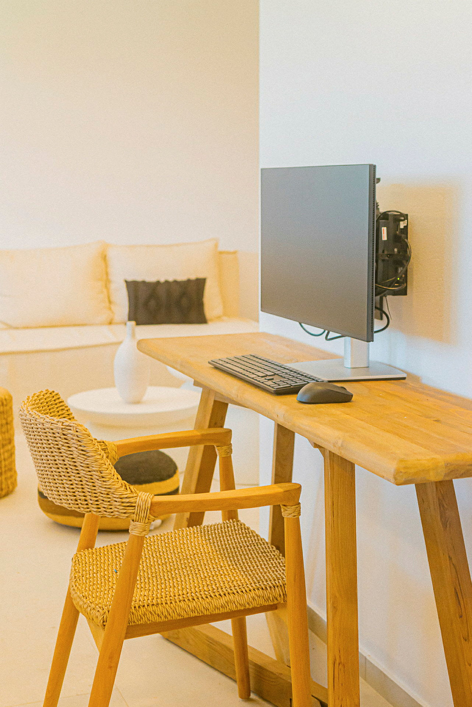 En arbeidsplass med et skrivebord i tre, stol og dataskjerm. (AI-generert tekst)