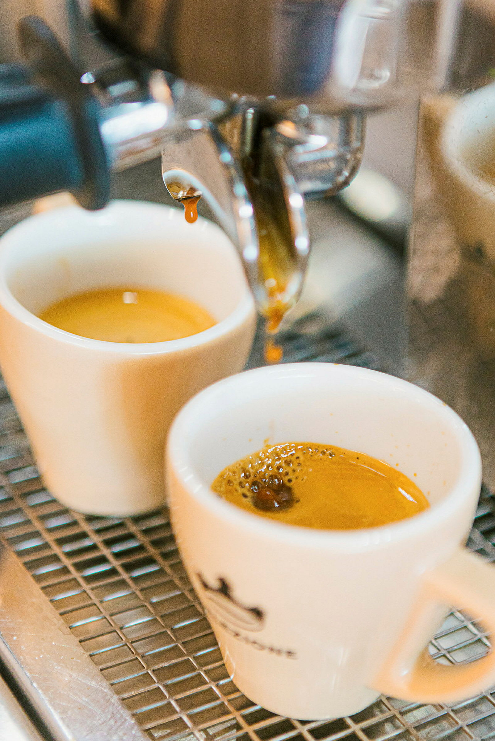 Espressobrygging med to hvite kopper under maskinen. (AI-generert tekst)