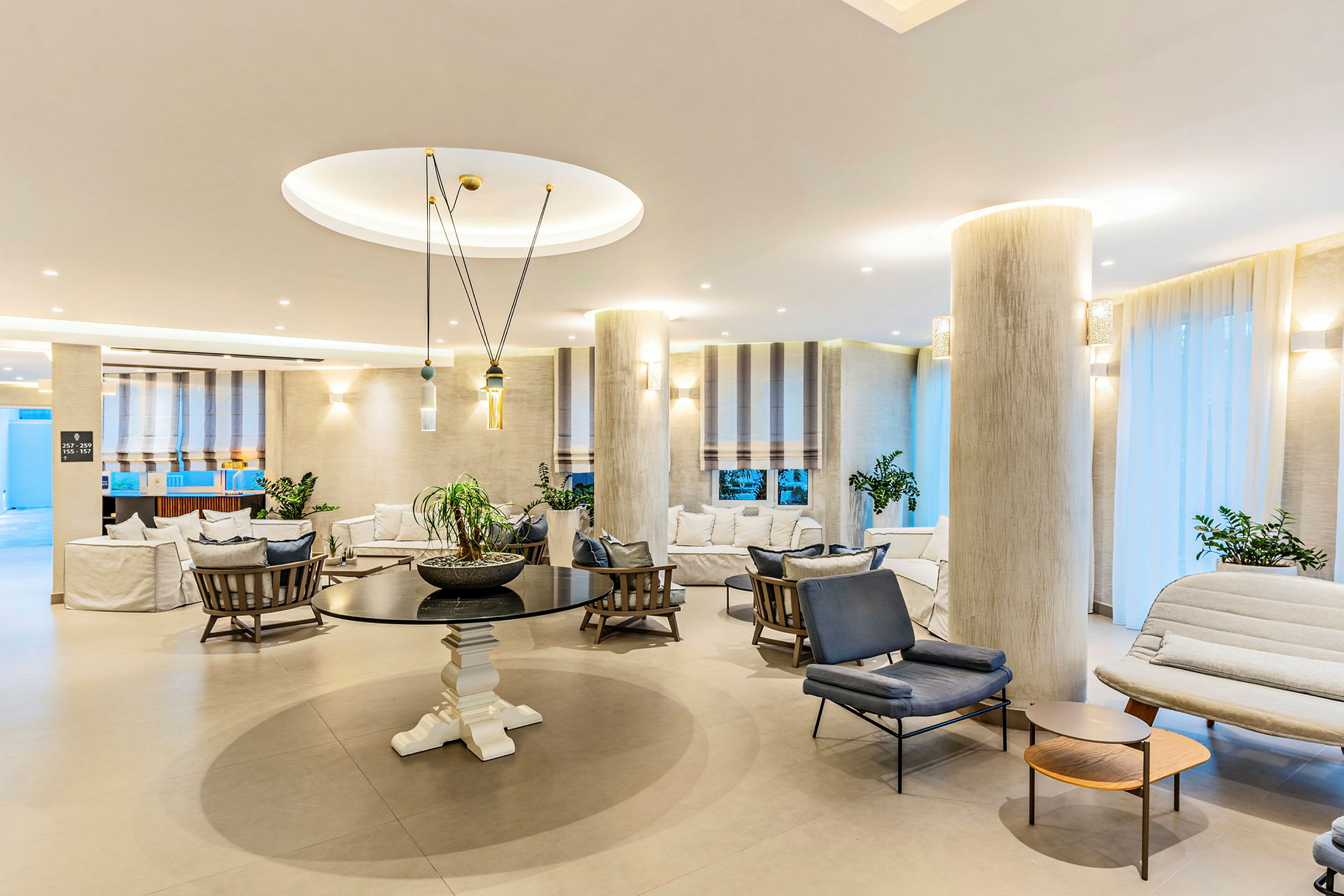 Lyst og stilfullt innredet hotellobbymiljø med sittegrupper og dekorative elementer. (AI-generert tekst)