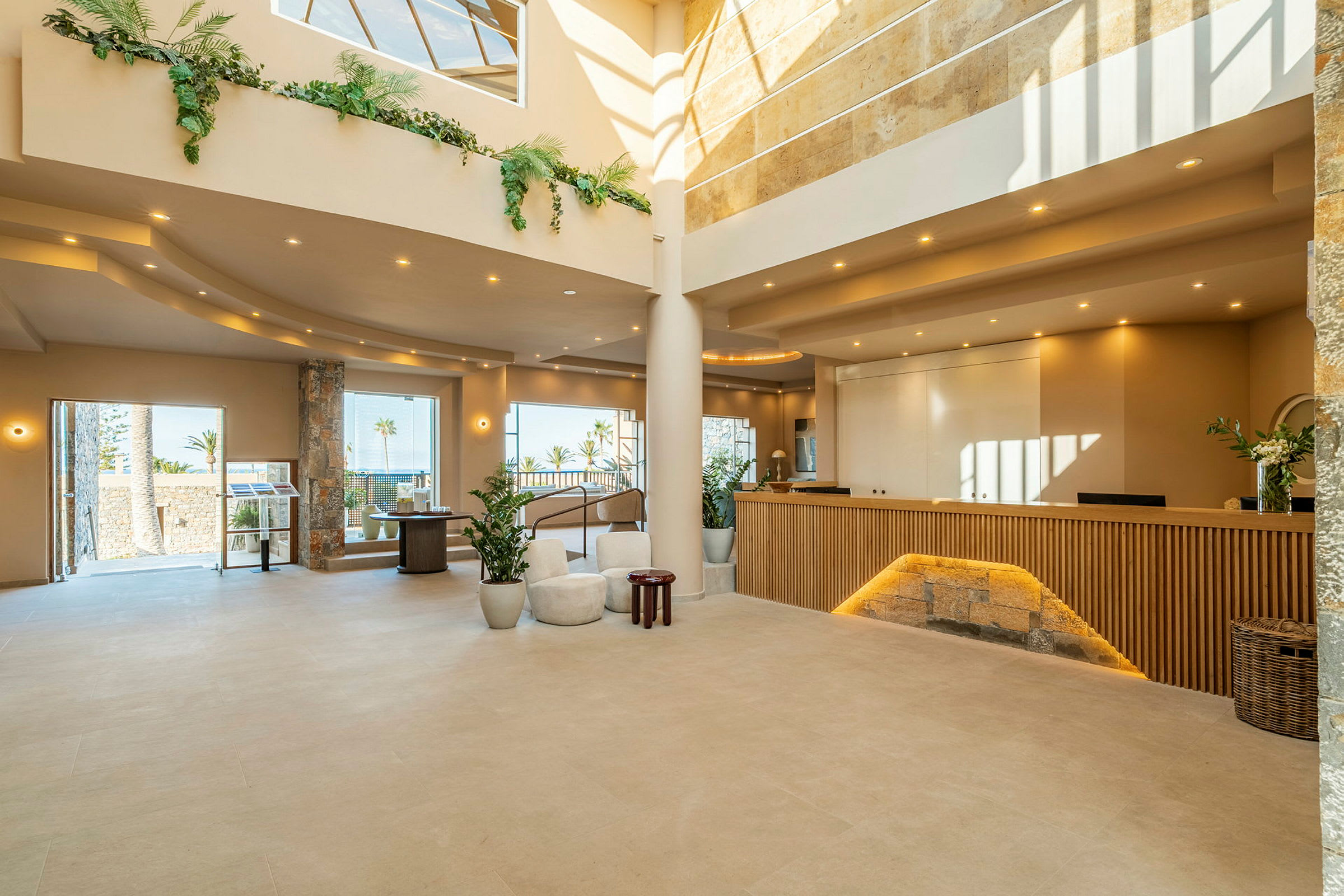 En moderne hotellobby med en resepsjonsdisk og store vinduer som slipper inn dagslys. (AI-generert tekst)